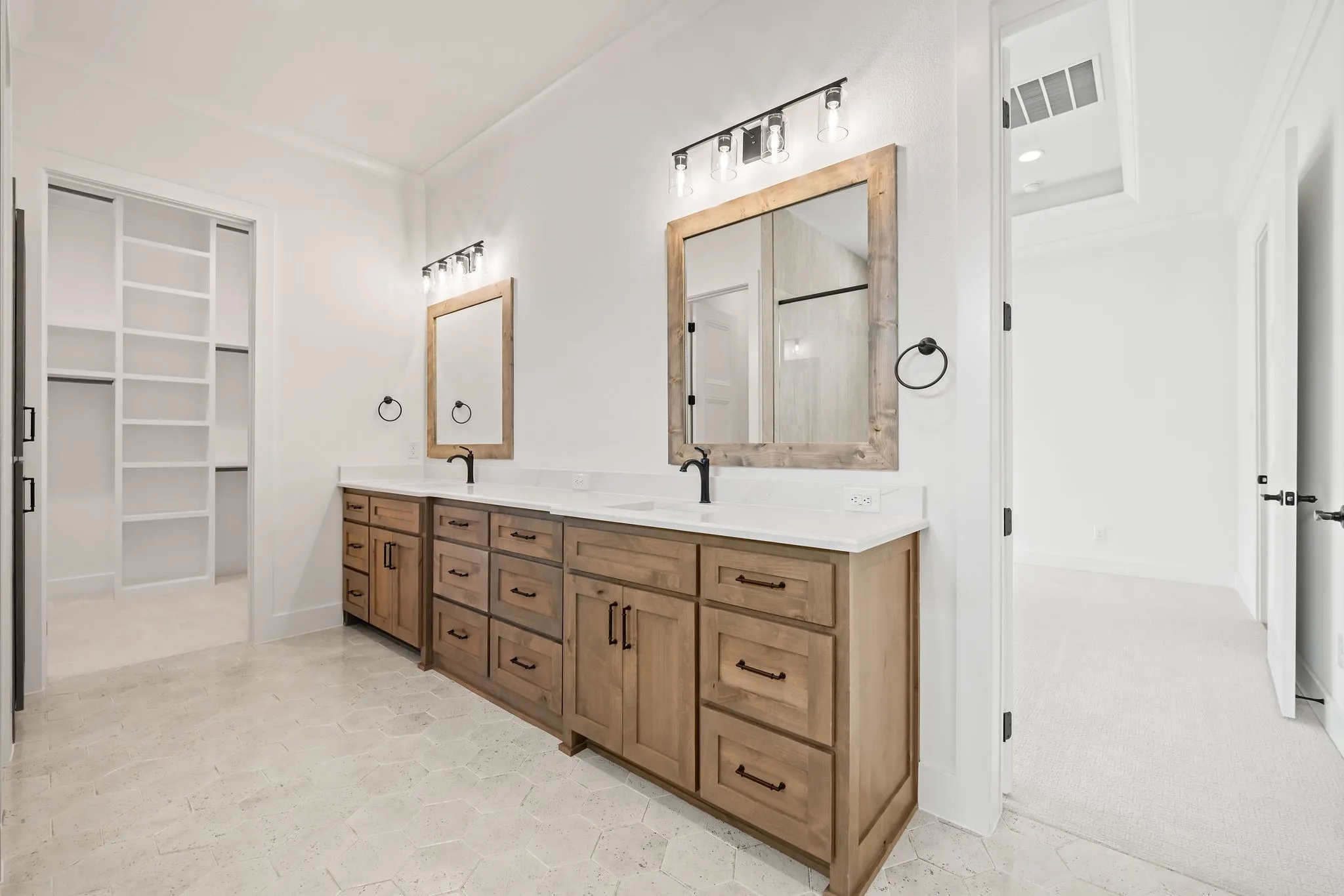 Dual wood-finish vanities with white countertops and undermount sinks