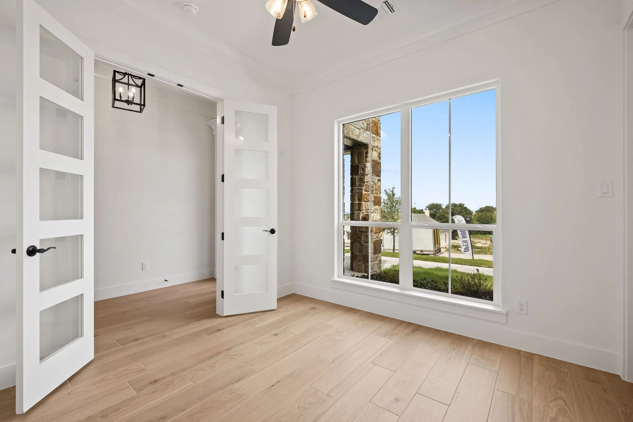 Bright interior space featuring wood-finish flooring, white walls, and crown molding