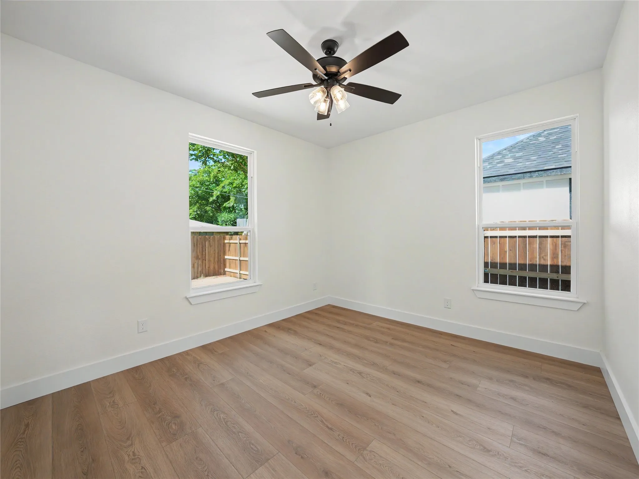 Bright interior room featuring wood-finish flooring, white walls, and white trim