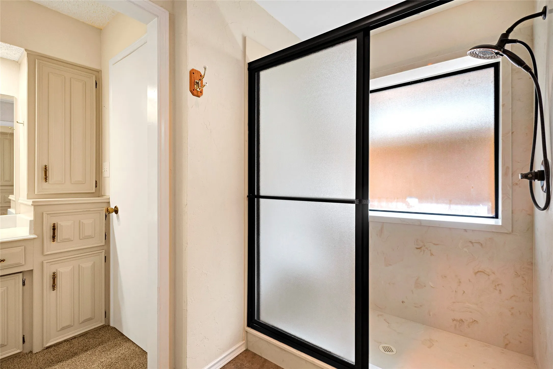 Shower enclosure with frosted sliding glass doors and black framing