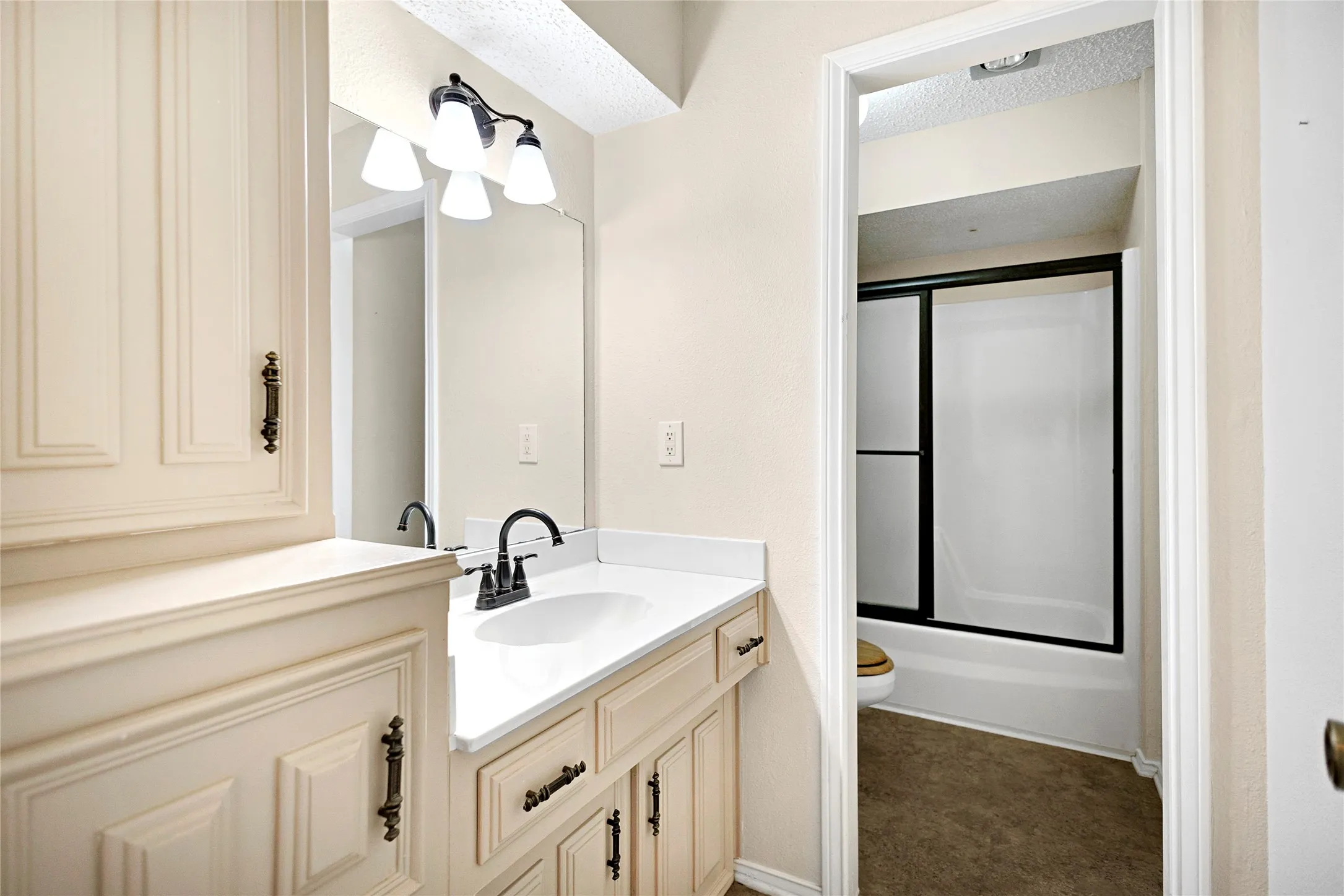 Bathroom vanity with a white countertop and integrated sink, complemented by black-finish hardware and a matching faucet