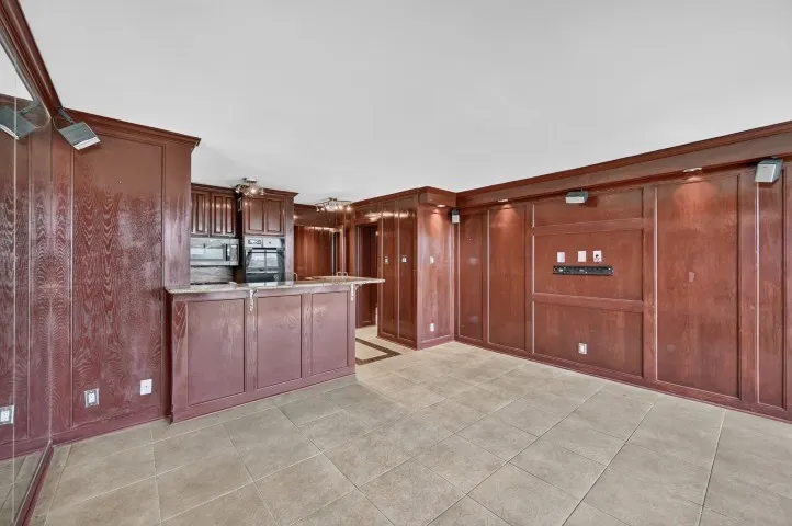 Kitchenette featuring wood cabinetry, stone countertops, and built-in appliances