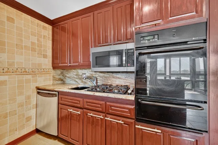 Kitchen featuring wood-finish cabinetry, built-in wall oven, microwave, and dishwasher