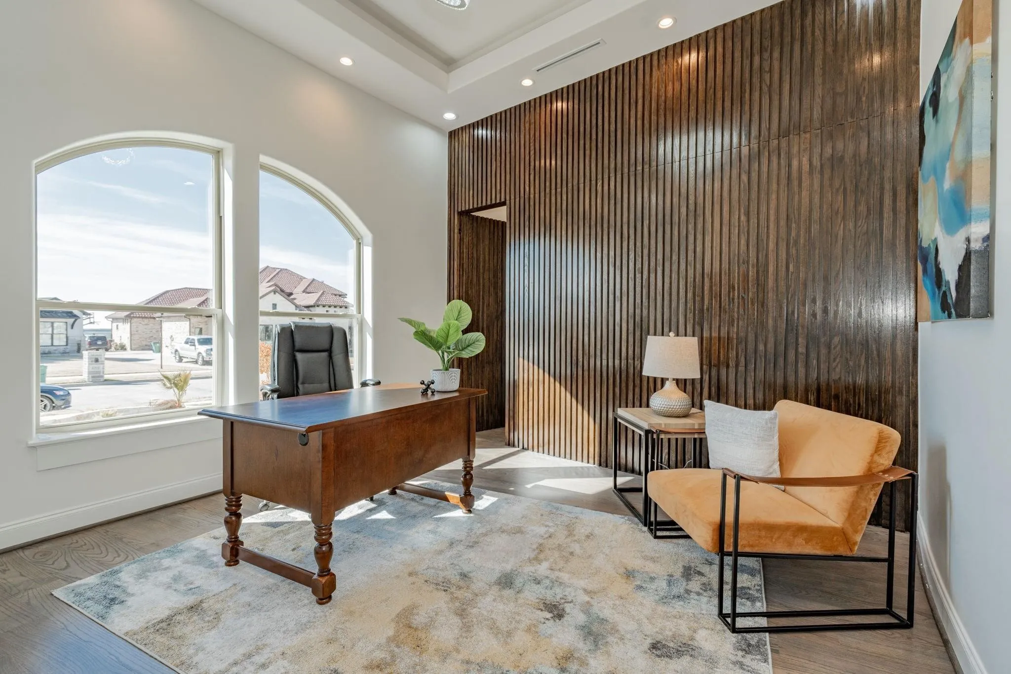 Room featuring a striking wood slat accent wall, recessed lighting, arched windows, and wood-finish flooring