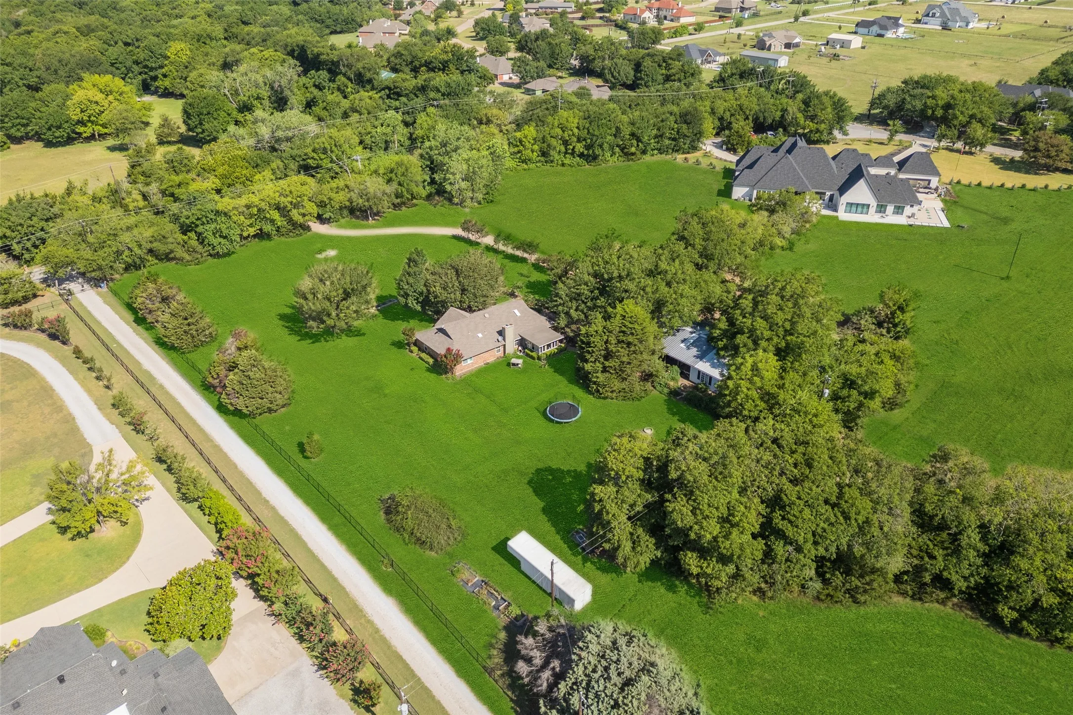 Expansive green property featuring multiple residences and extensive tree coverage