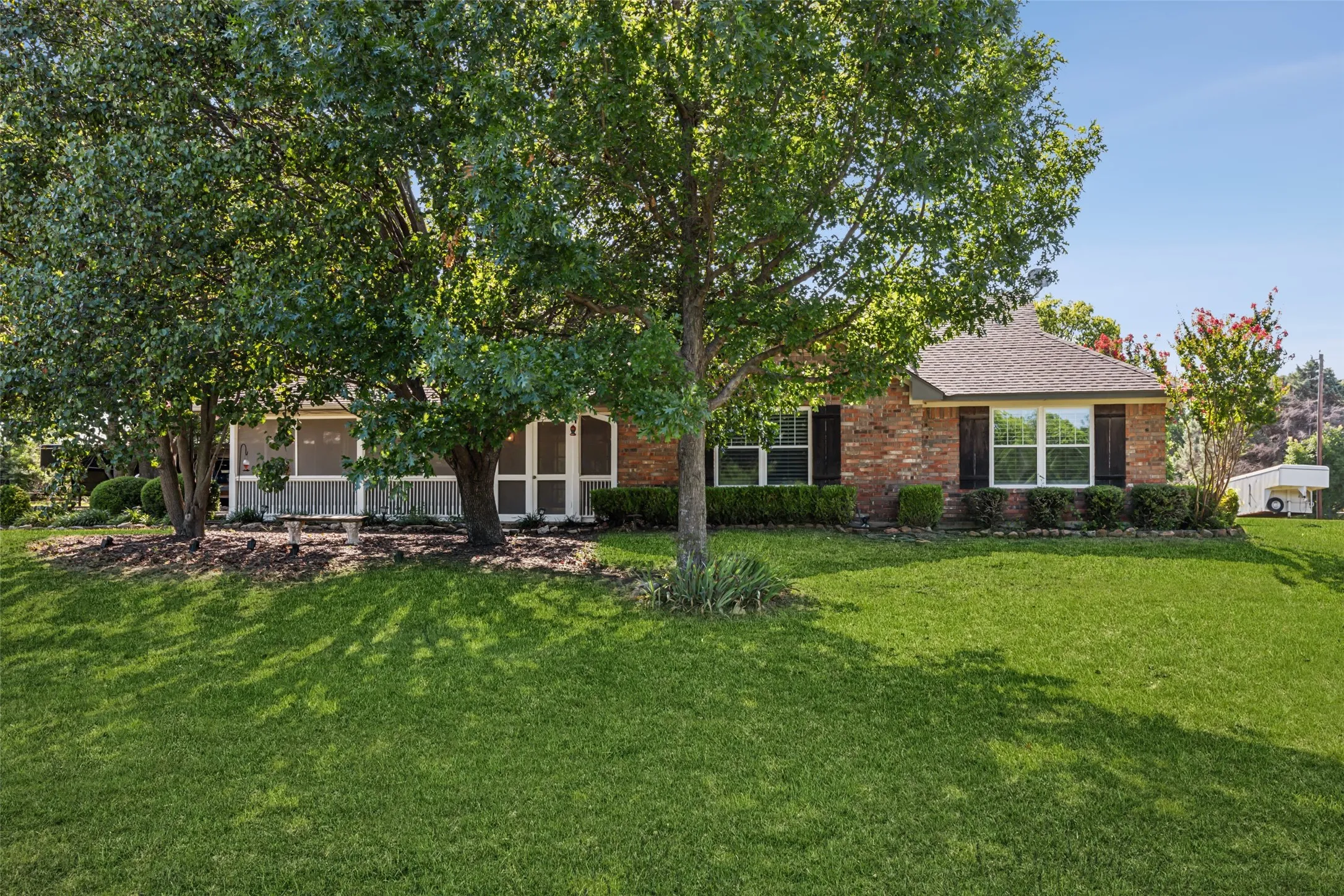 Brick exterior with white-framed windows and dark shutters