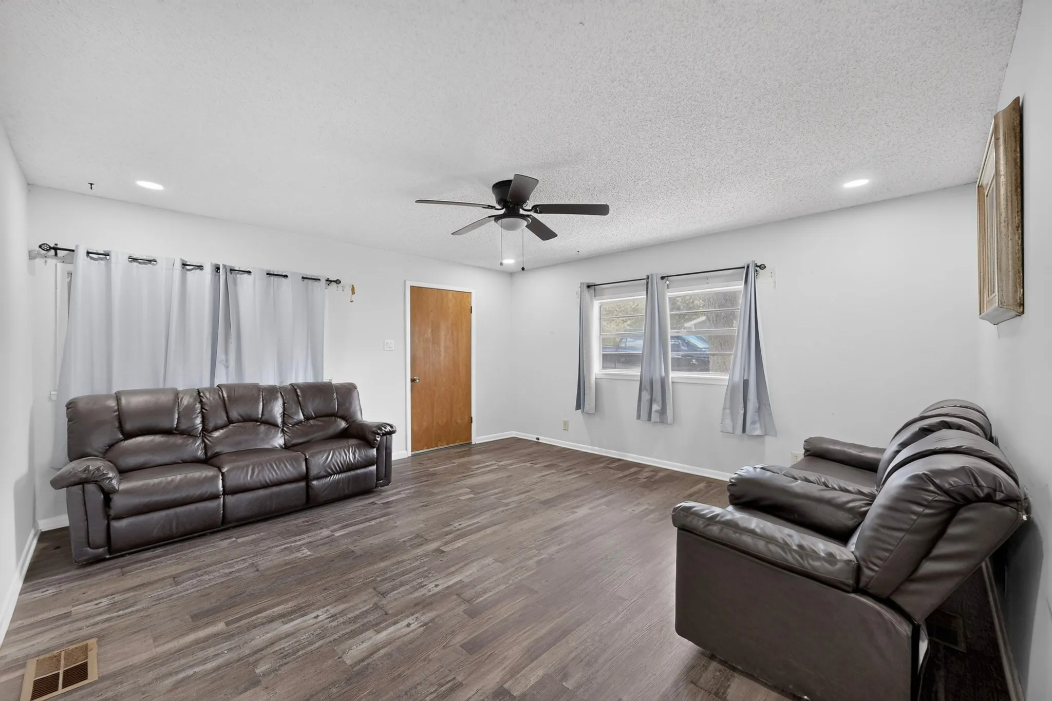 Spacious interior with wood-finish flooring, recessed lighting, and a ceiling fan