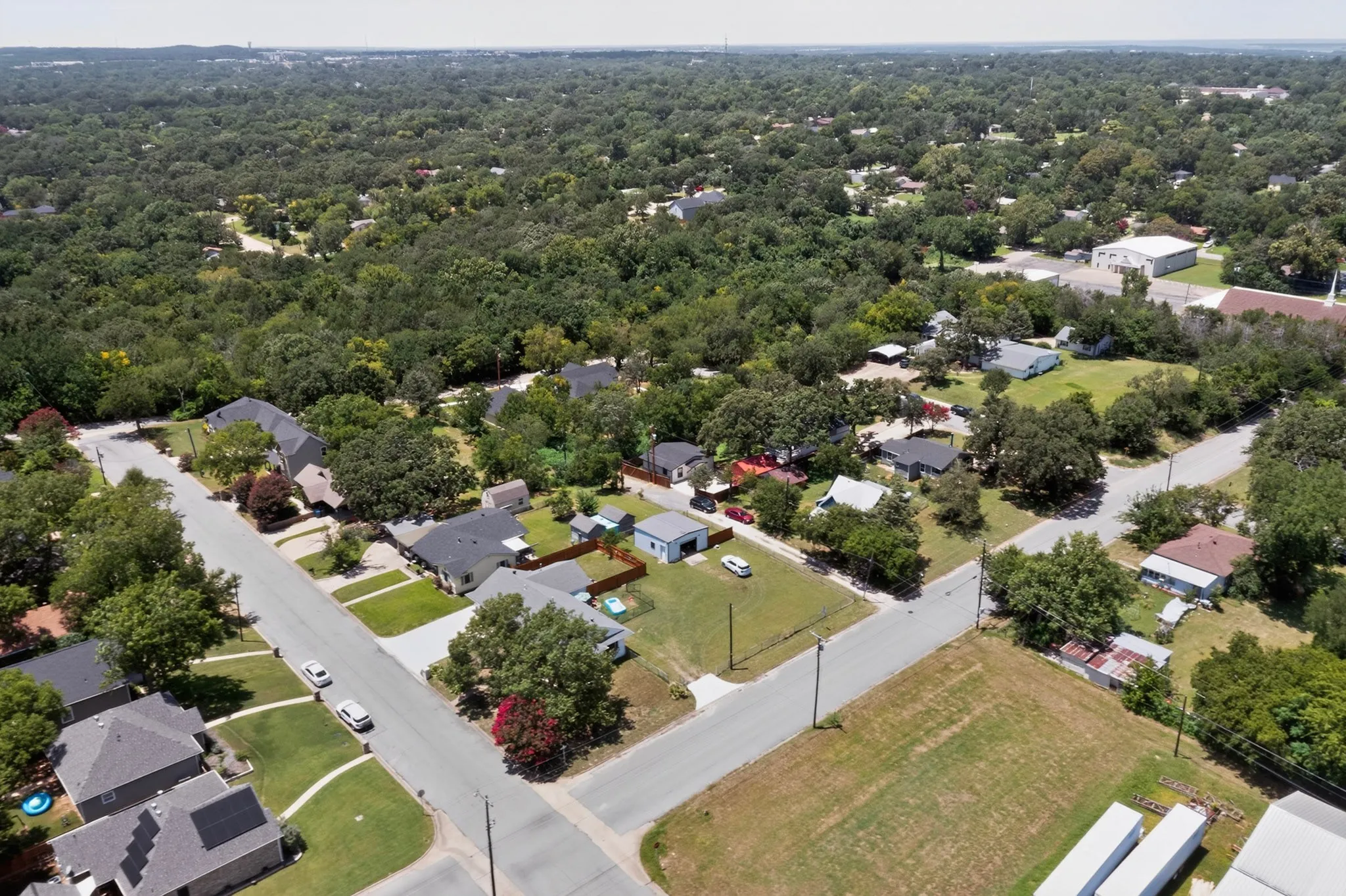Aerial perspective showcasing a residential neighborhood with extensive tree canopy