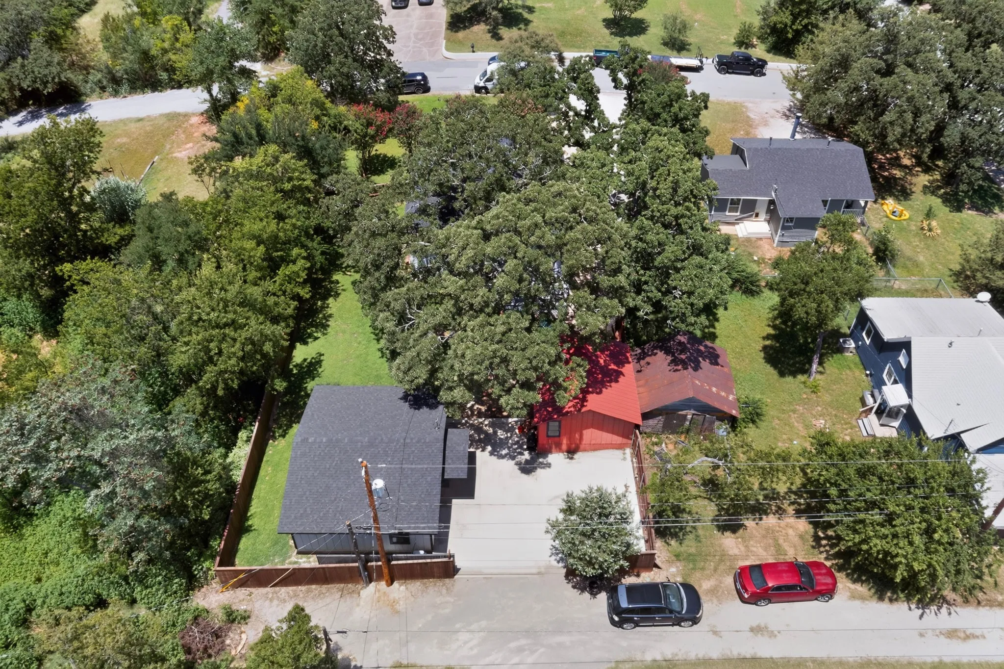 Property featuring a dark gray roofline, a gravel driveway, and a wooden privacy fence