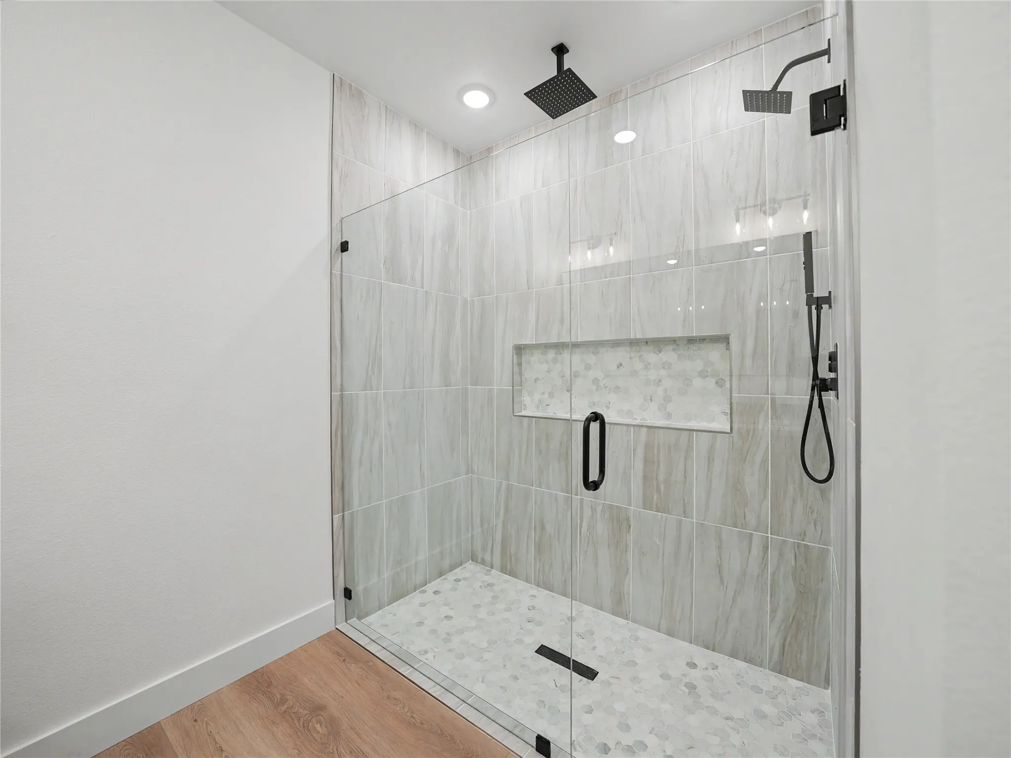 Walk-in shower with clear glass enclosure and matte black hardware