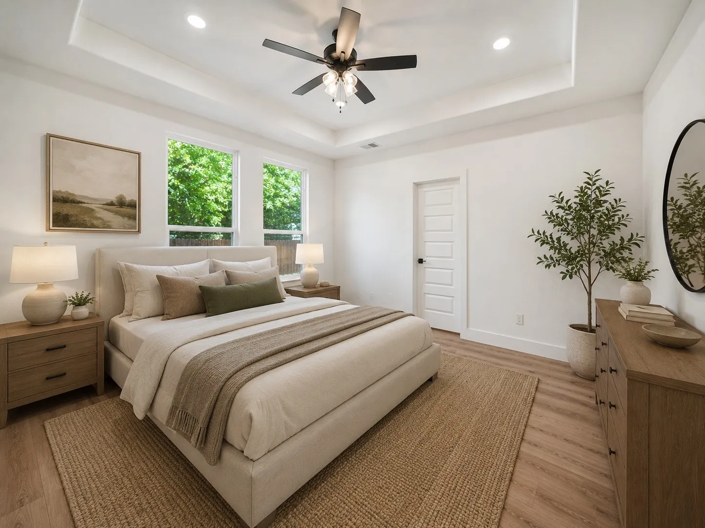 Spacious bedroom with a tray ceiling, recessed lighting, and a ceiling fan