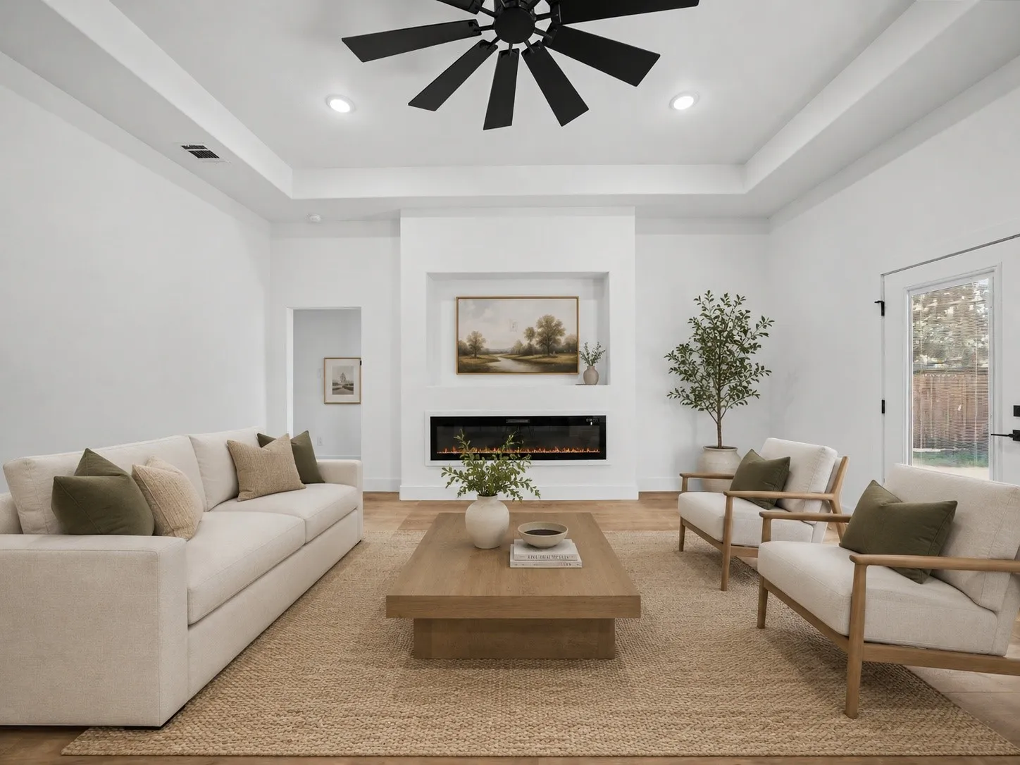 Spacious living area featuring high tray ceilings, recessed lighting, and wood-finish flooring