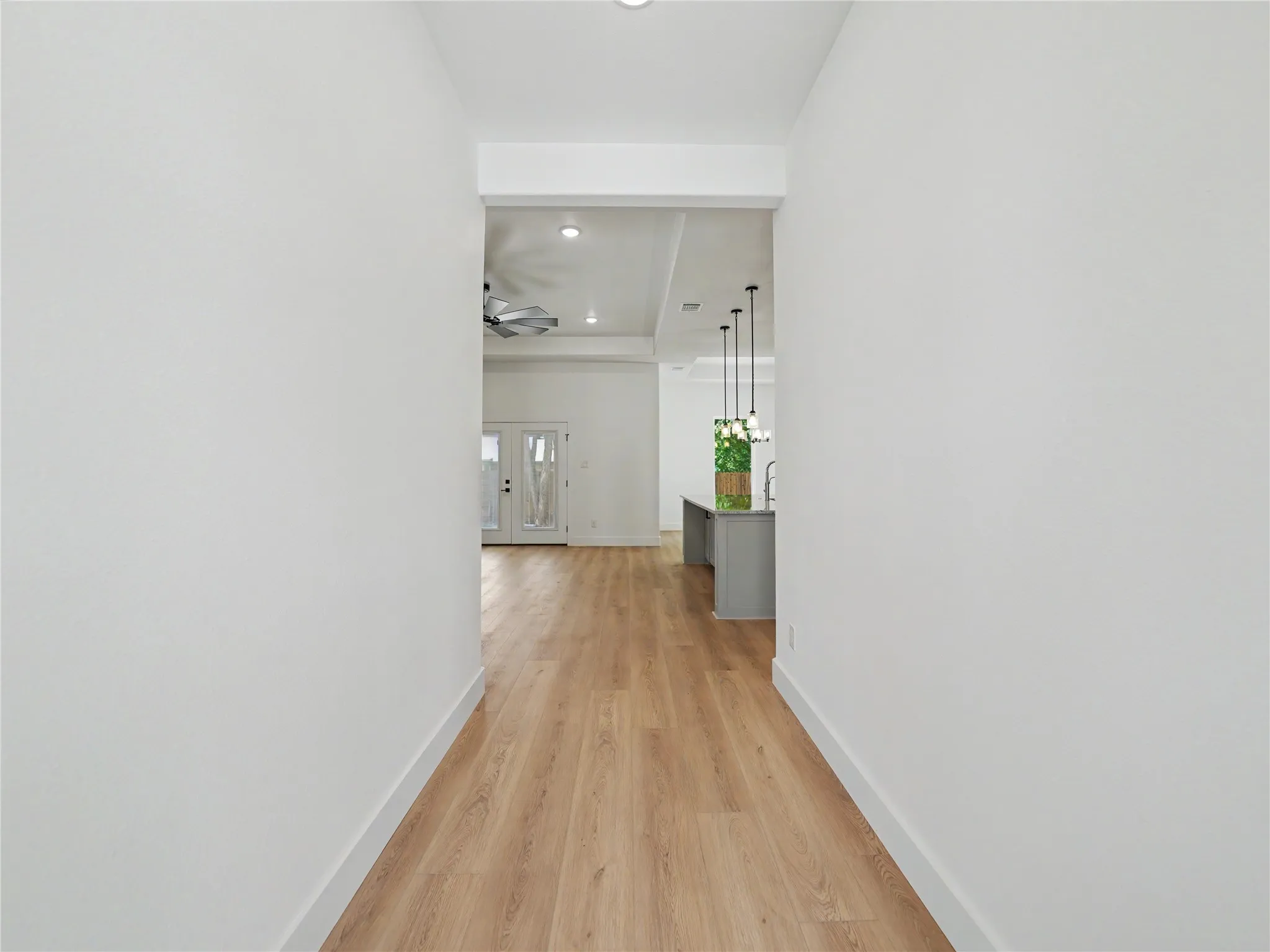 Hallway entry featuring wood-finish flooring, white walls, and a recessed ceiling light