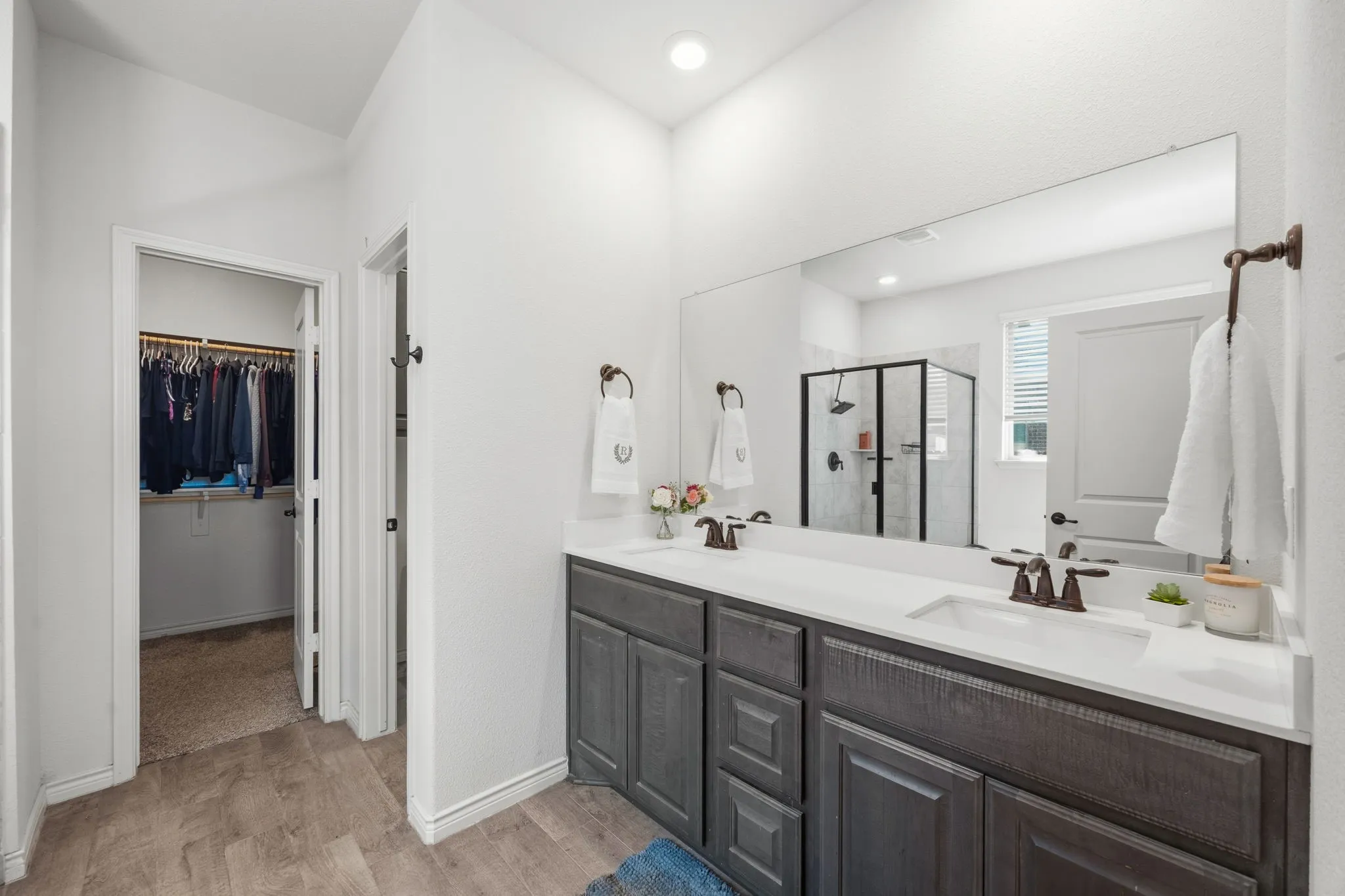 Bathroom featuring a dual vanity with dark wood-finish cabinetry and white countertops