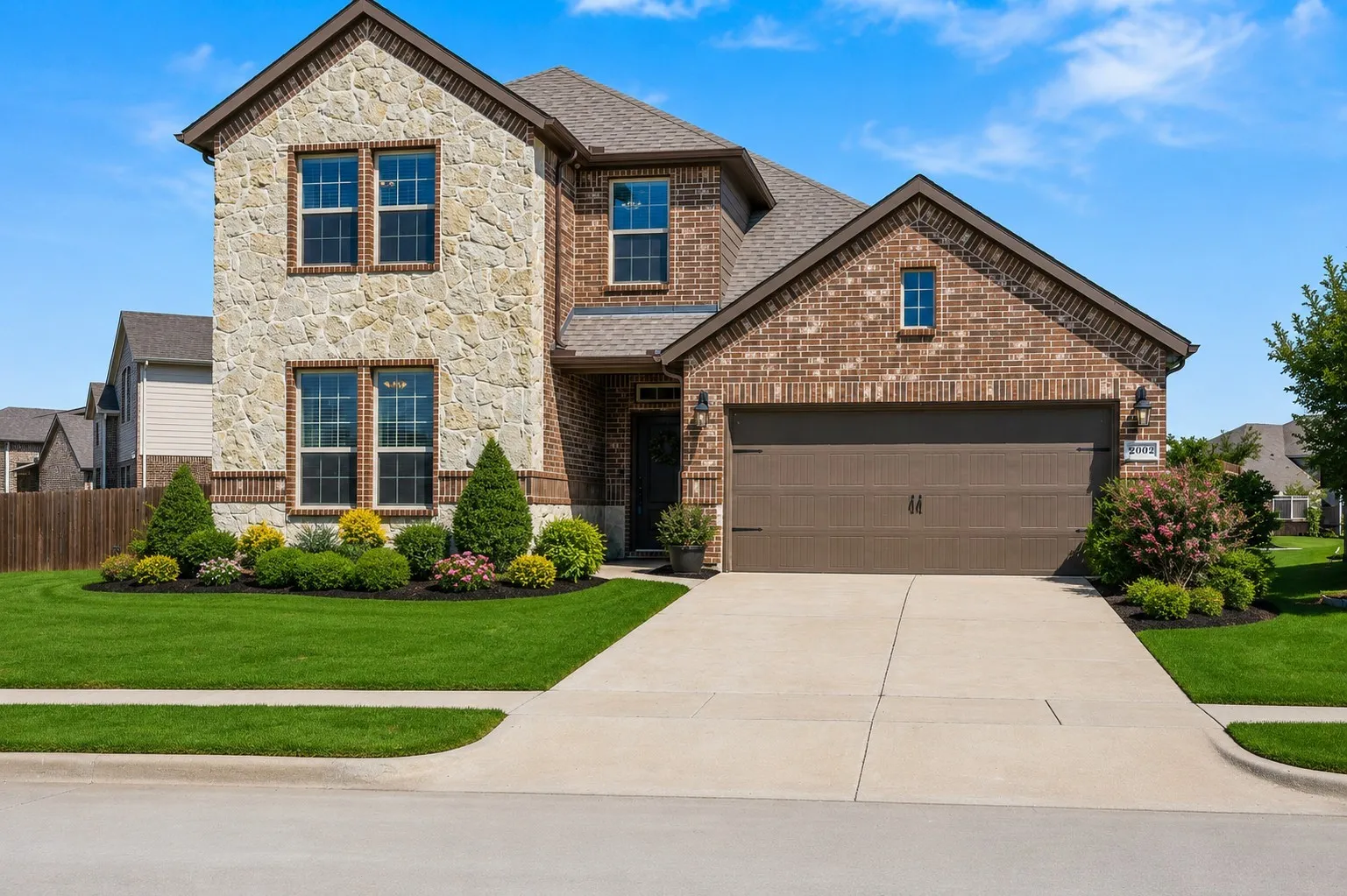Stately two-story residence featuring a combination stone and brick facade