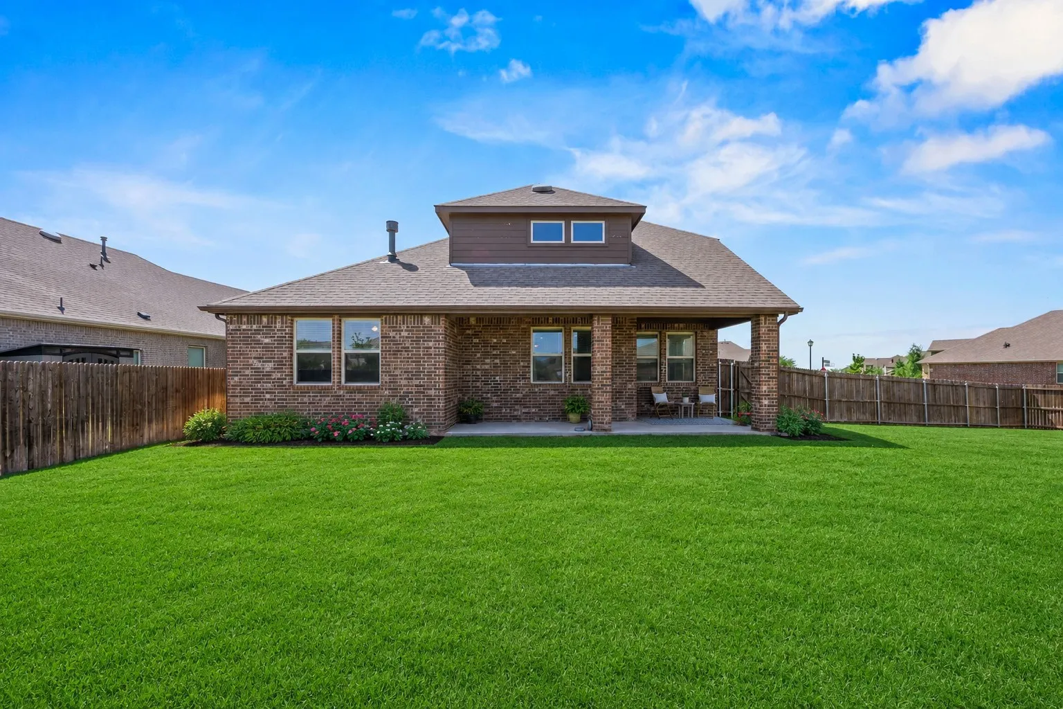Expansive green lawn with a full wooden privacy fence