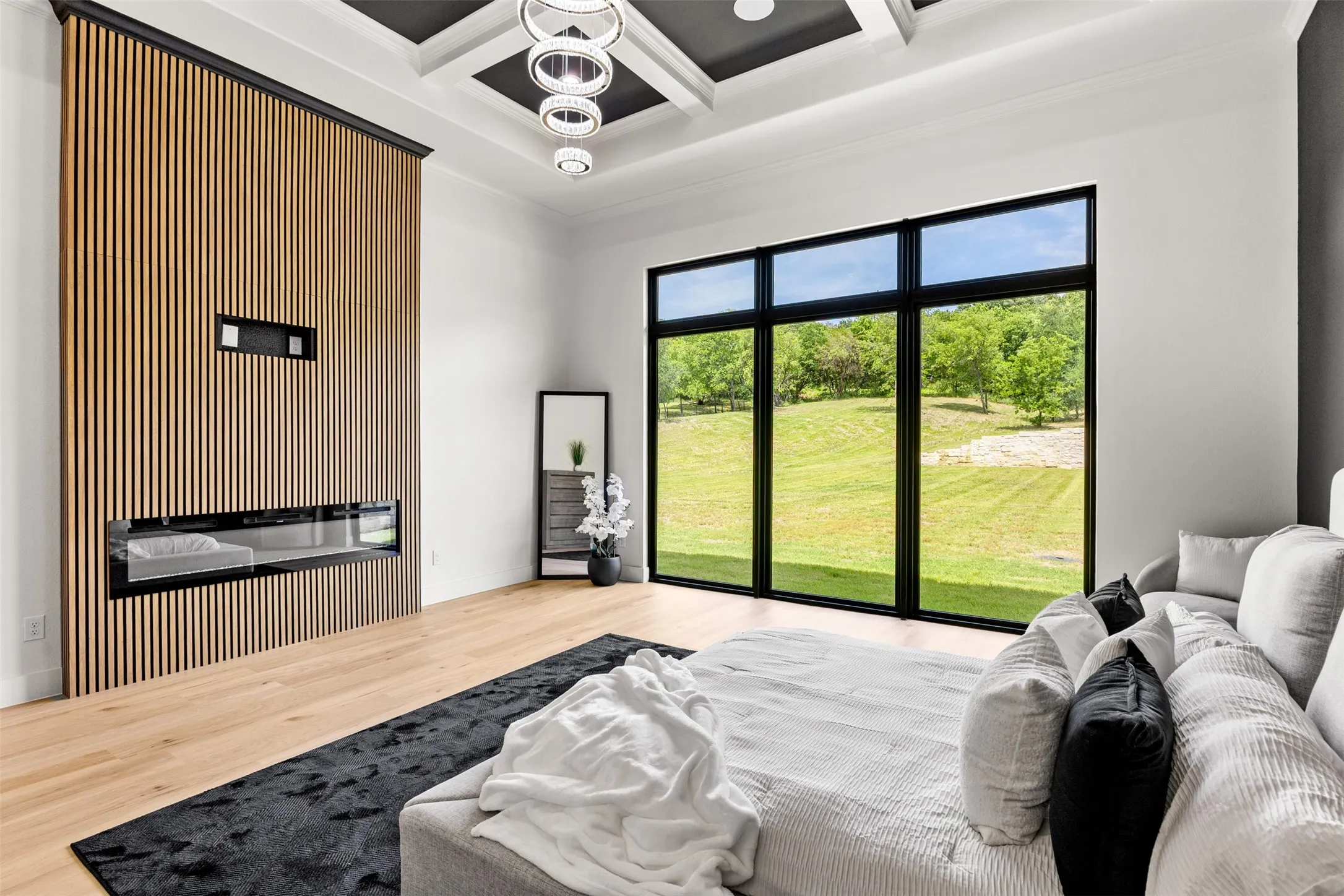 Expansive room featuring a wood-slat accent wall with an integrated fireplace and a large window overlooking green landscape
