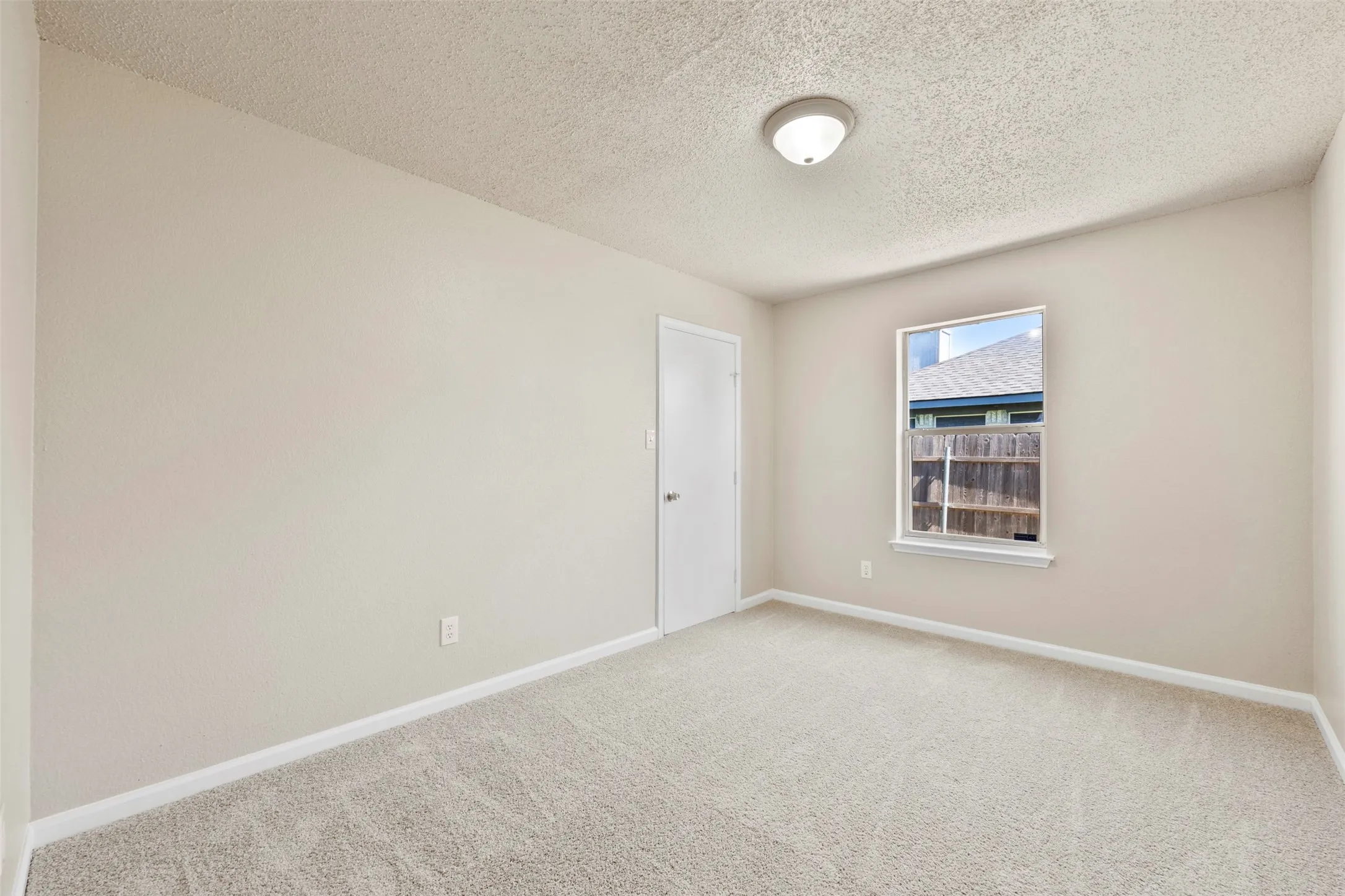 Light-colored walls in a neutral tone with a contrasting white baseboard