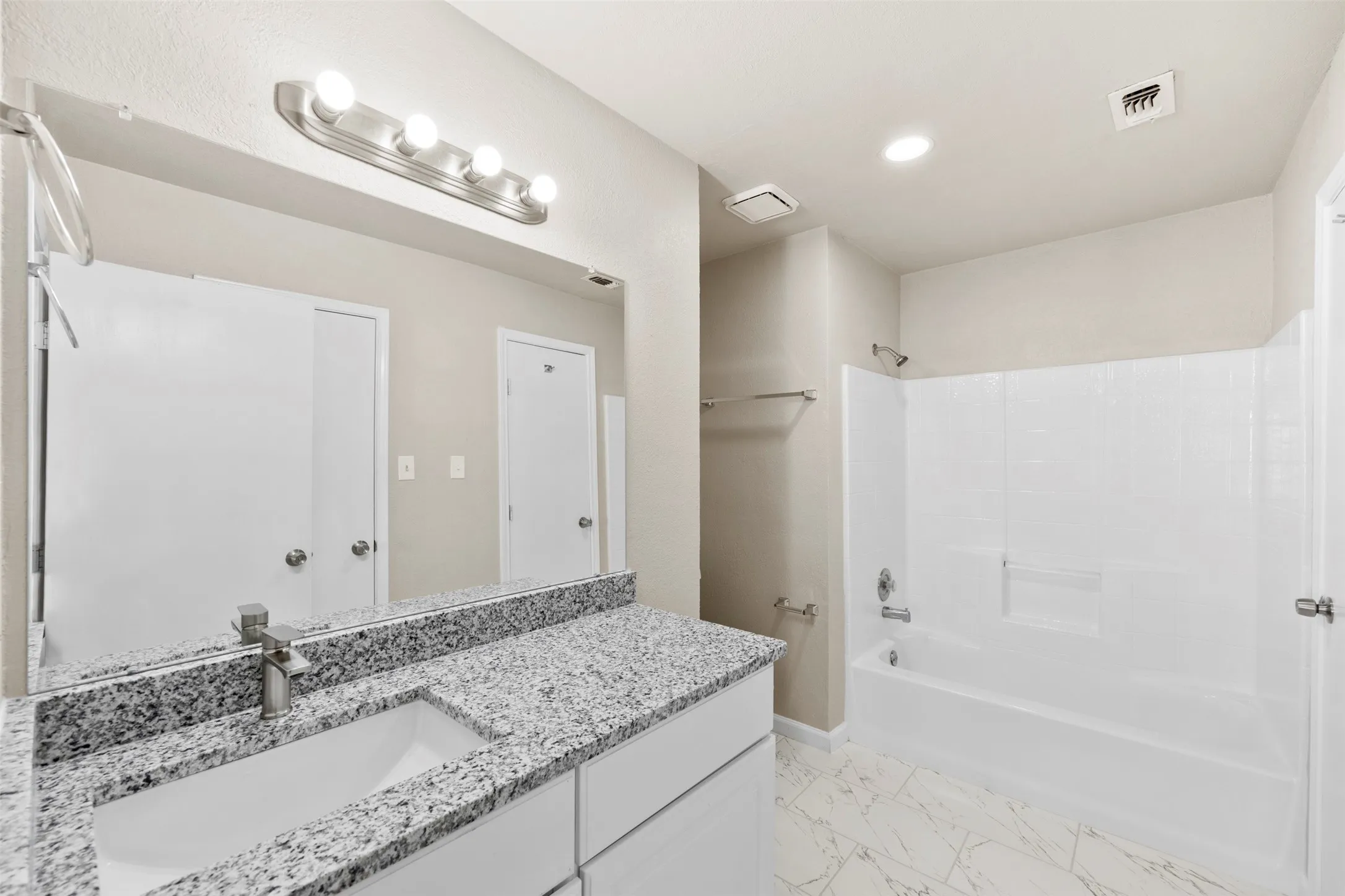 Bathroom featuring a vanity with a light-colored countertop, an undermount sink, and a modern single-handle faucet