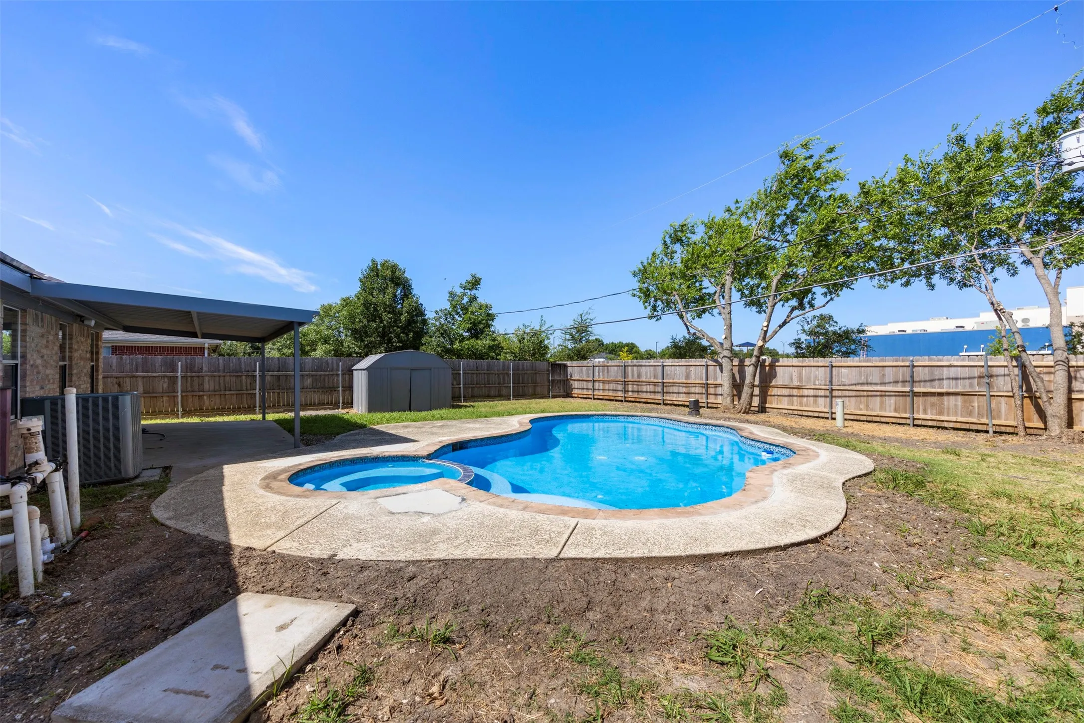 Backyard oasis featuring a freeform swimming pool with integrated spa