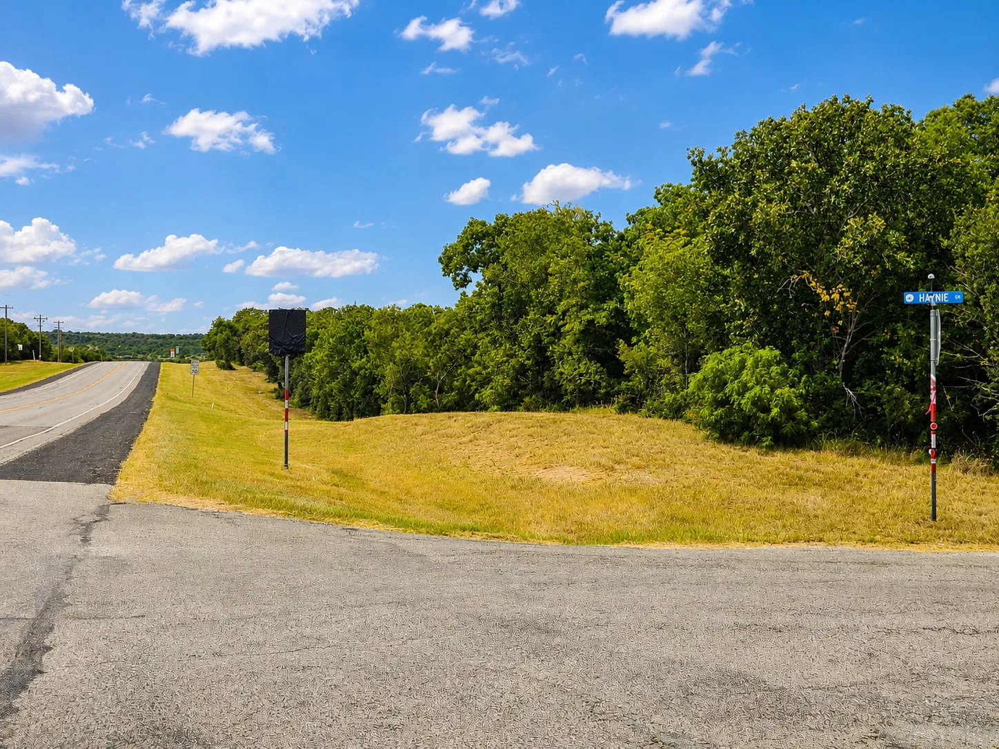 Expansive lot featuring mature trees and a substantial grass-covered area