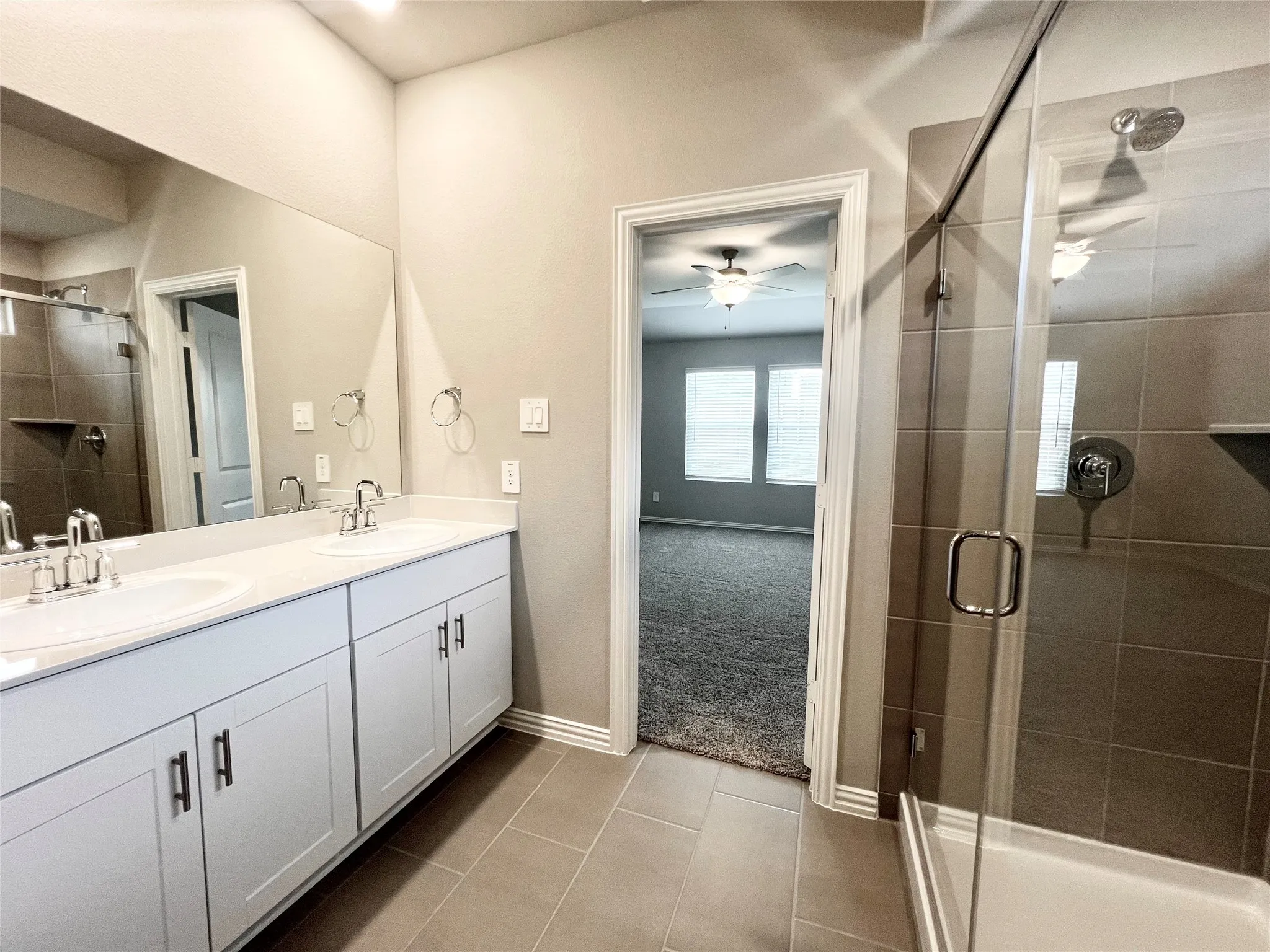 Bathroom featuring a double vanity with white cabinetry, light-colored countertops, and dual integrated sinks