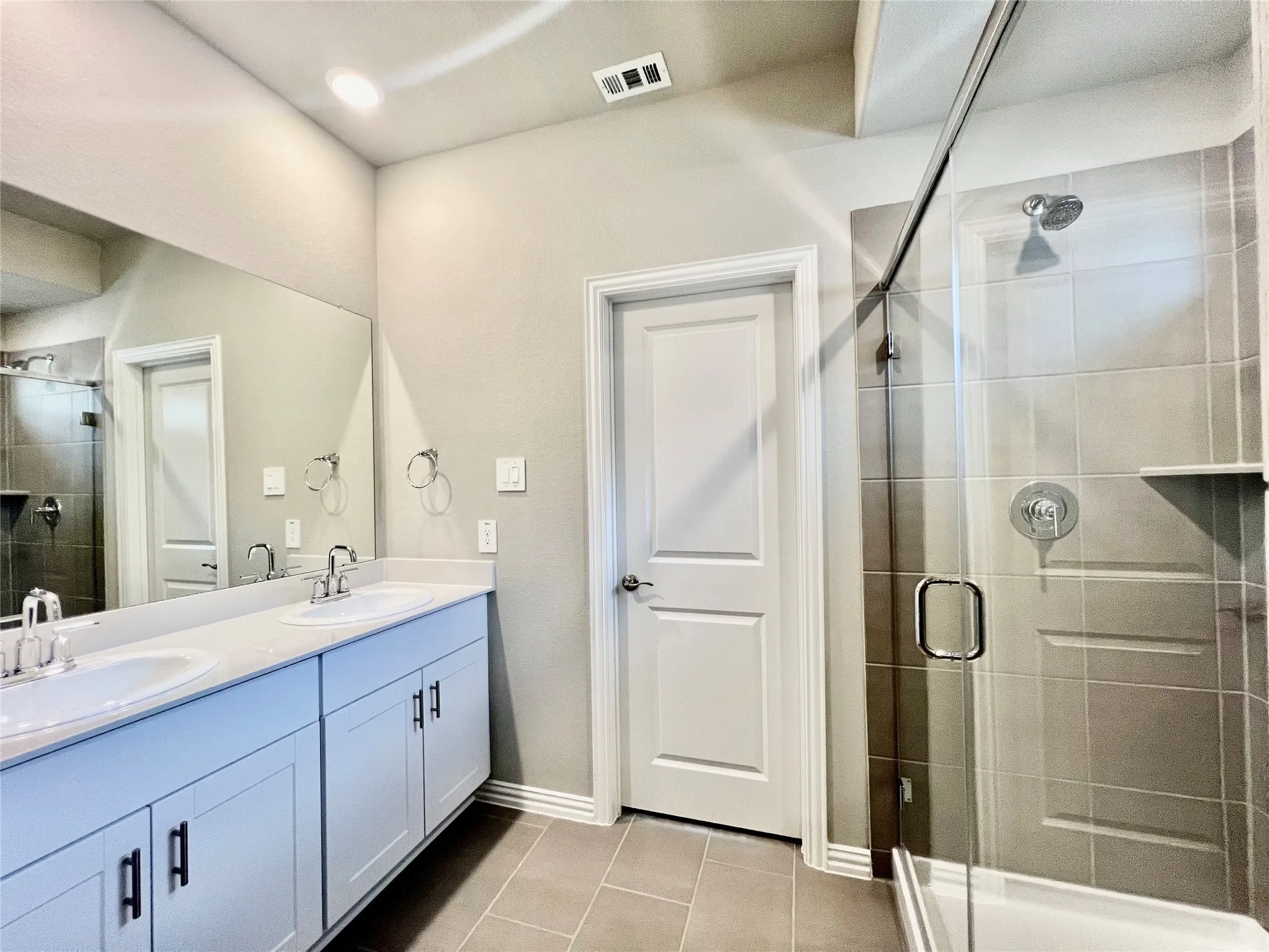 Bathroom featuring a dual vanity with undermount sinks and light-colored countertops