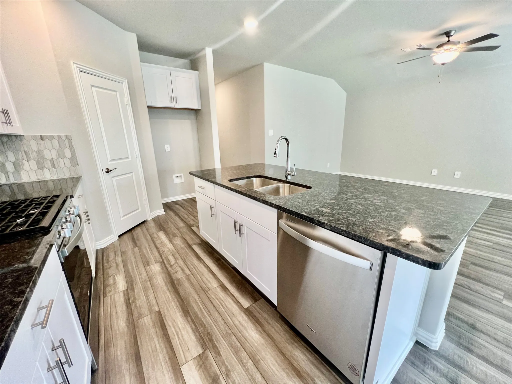 Kitchen island featuring a dual-basin stainless steel sink, gooseneck faucet, and integrated dishwasher