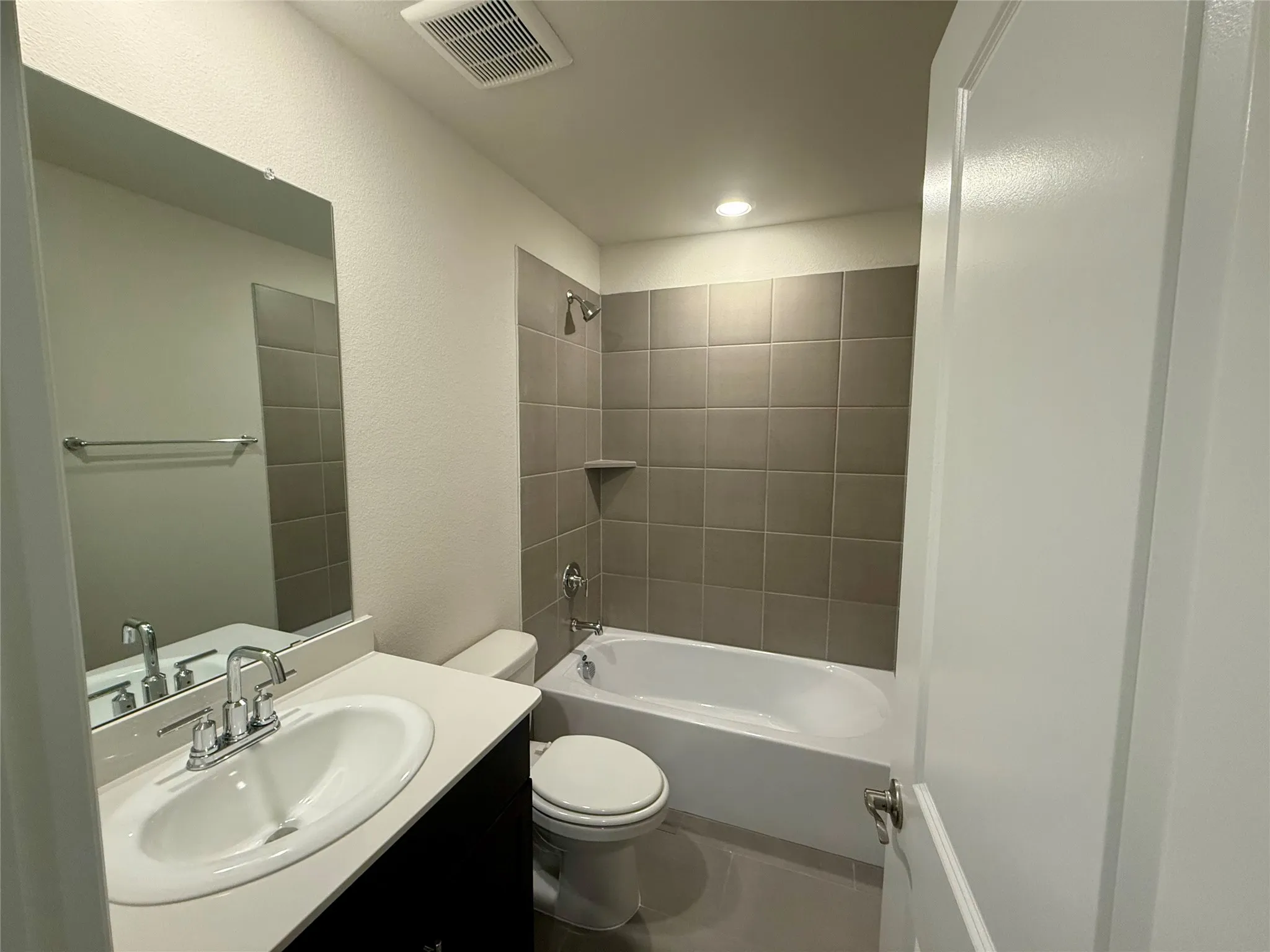 Bathroom featuring a vanity with an oval sink, chrome faucet, and solid surface countertop