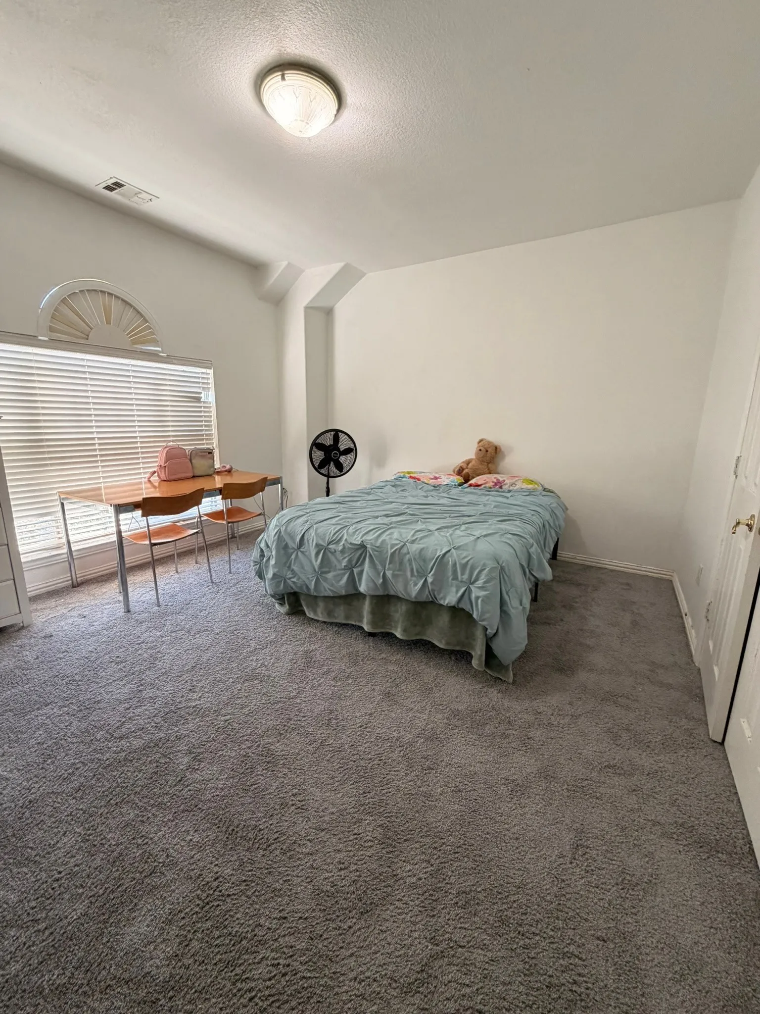 Bedoom #4 featuring vaulted ceilings, a large window with horizontal blinds, a decorative arched window accent, flush-mount ceiling lighting, and wall-to-wall carpeting