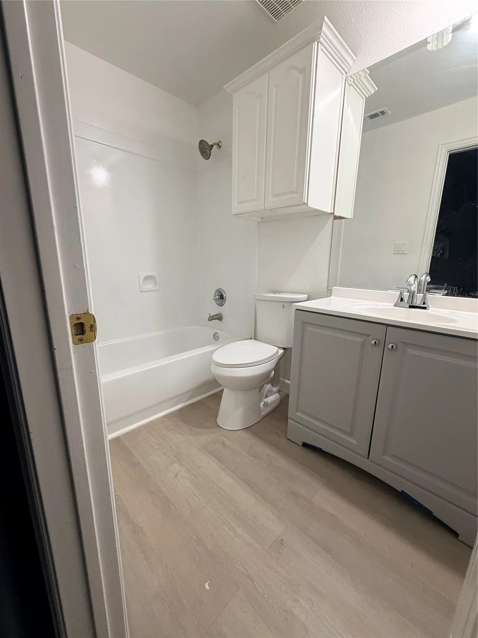 En suite bathroom with vanity, integrated sink, brushed nickel faucet, and a large wall-mounted mirror