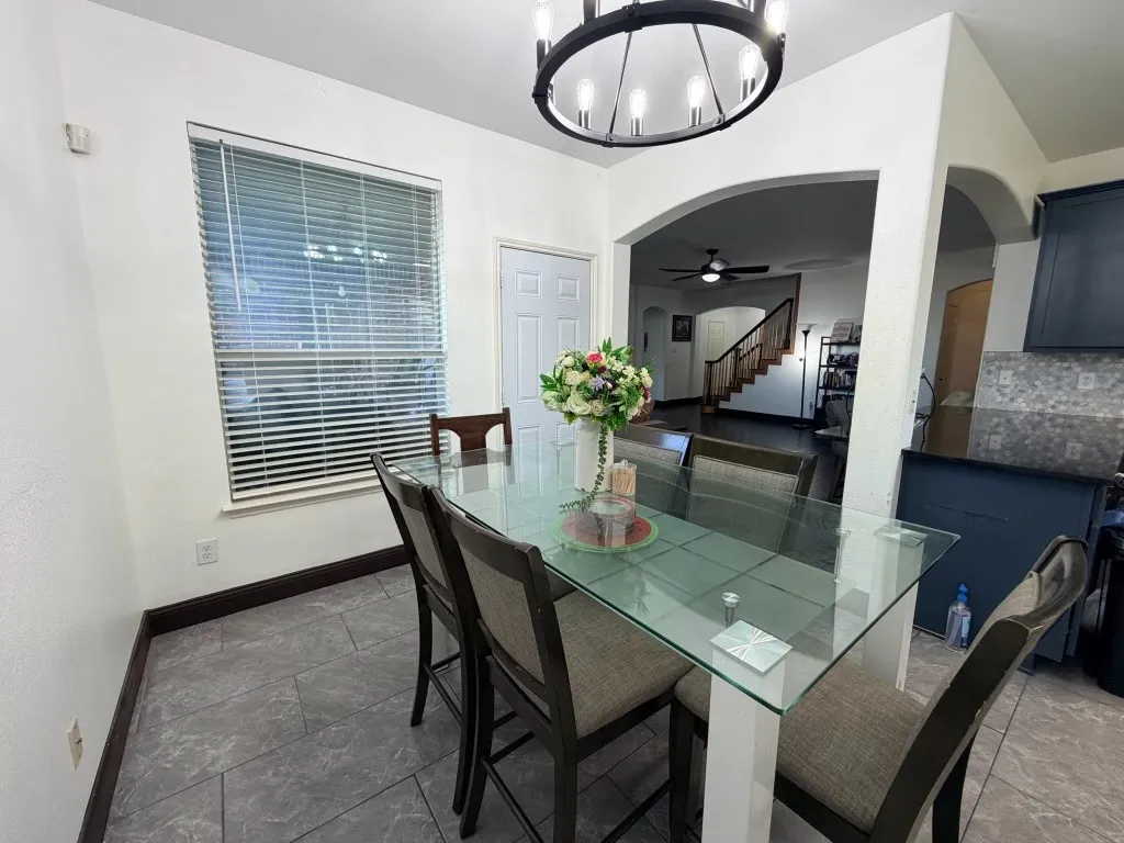 Dining area with tile flooring and a window with blinds