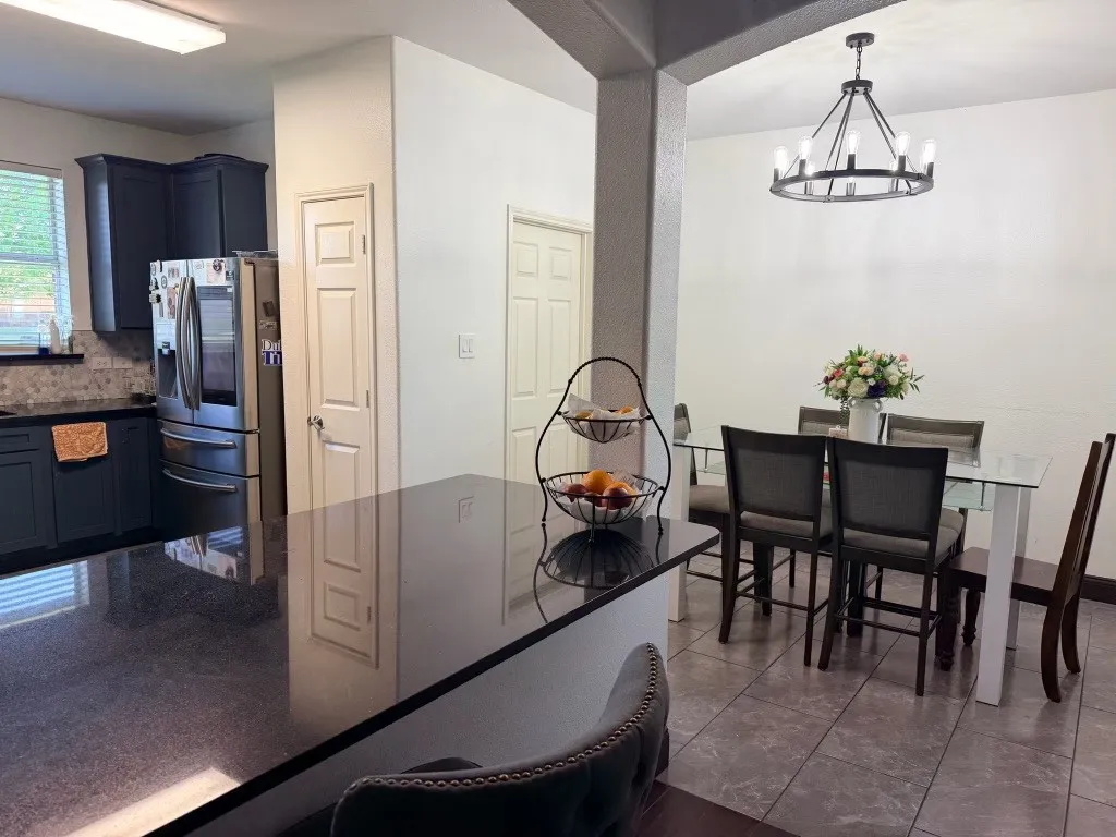 Kitchen featuring dark cabinetry, stainless steel appliances, and a mosaic tile backsplash