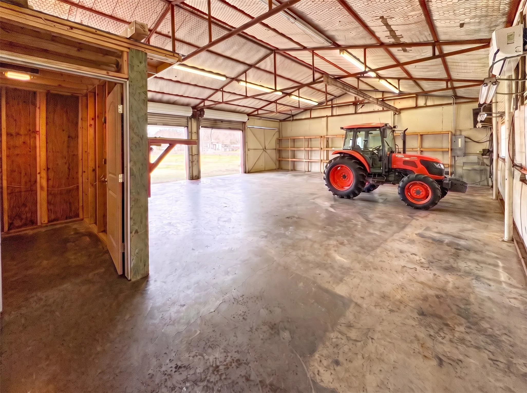 Climate-controlled workshop features electricity, a bathroom, and two roll-up doors. Virtually staged to illustrate potential shelving, storage and equipment placing.