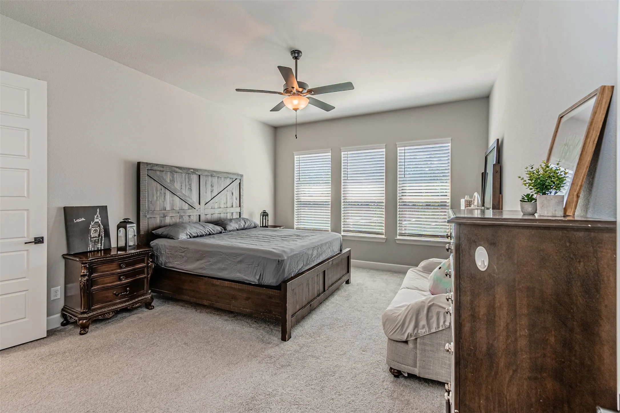 Carpeted flooring with multiple windows and a ceiling fan with integrated lighting