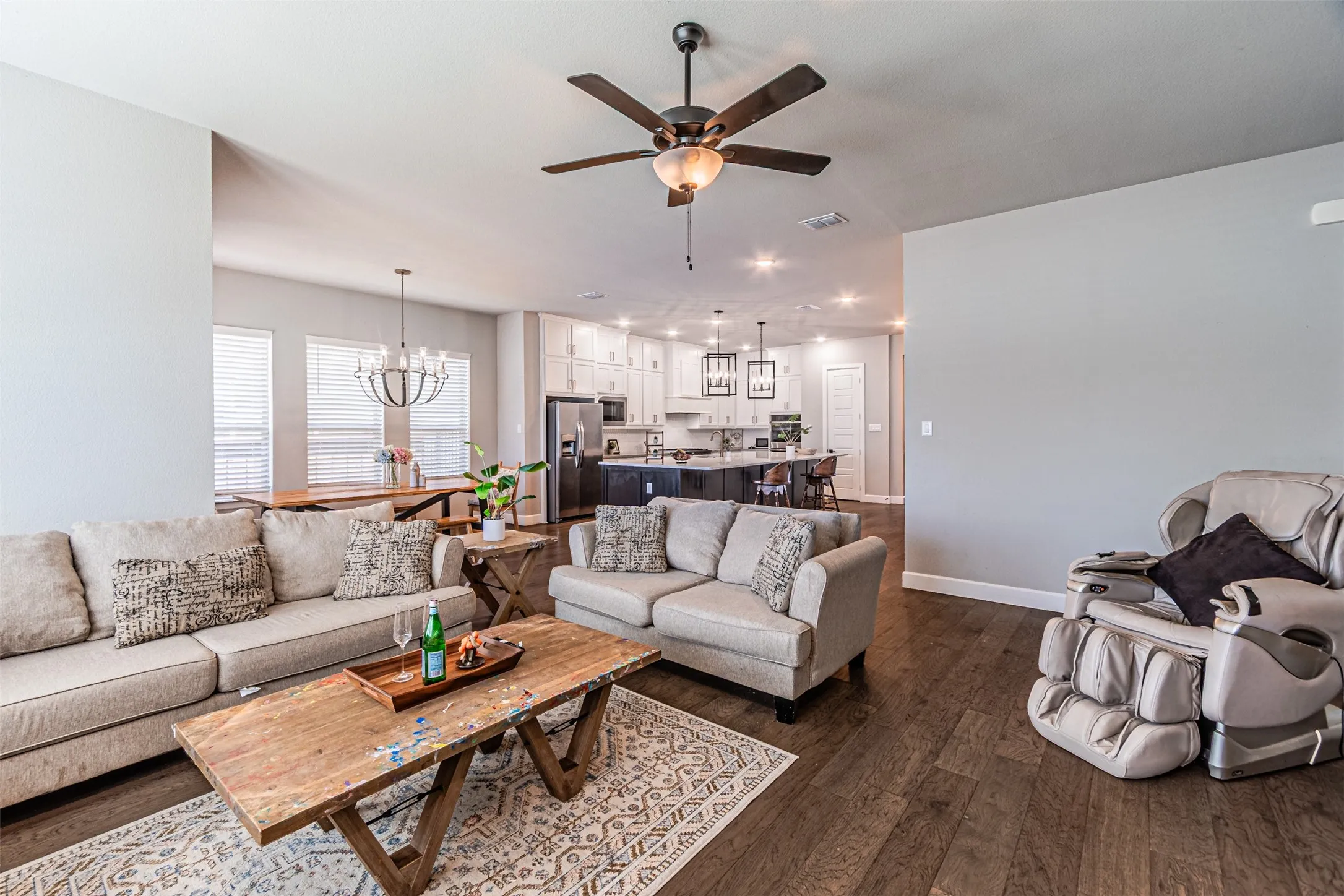 Spacious open-concept living area featuring wood-finish flooring, recessed lighting, and a ceiling fan