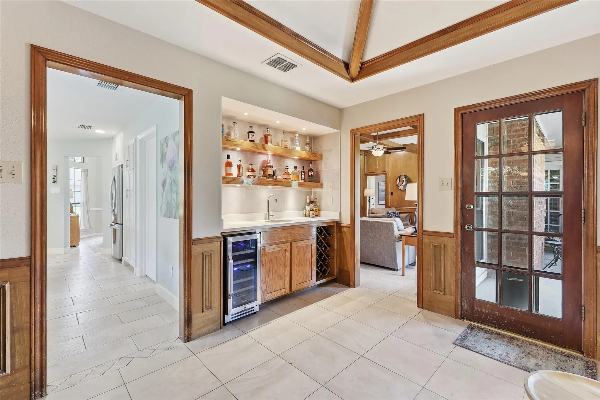 closer look at the wet bar with a wine cooler and wine storage.  The placement is easy access to the back patio, living room or kitchen.