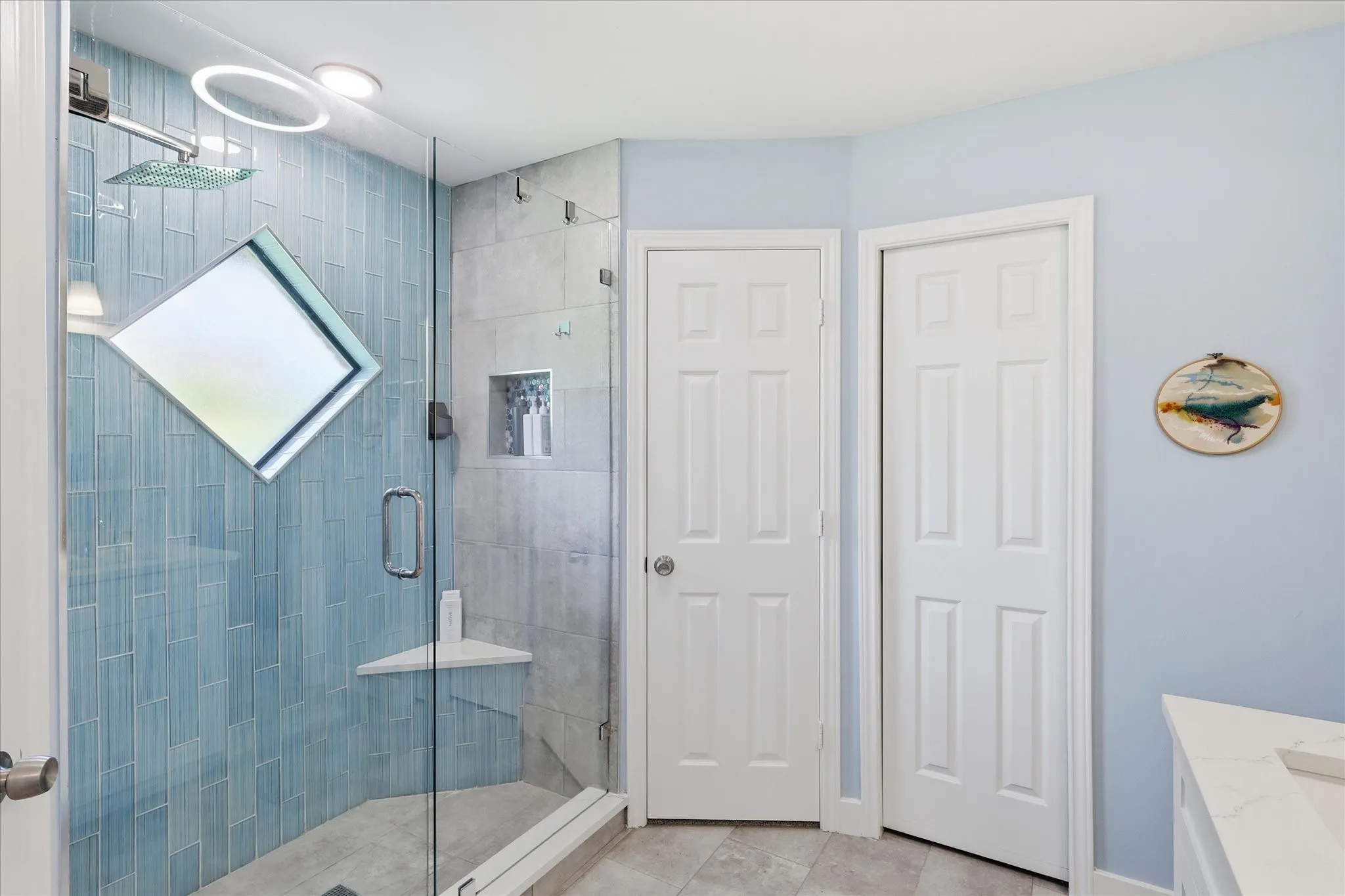 Shower features a soap niche and an angled shelf.