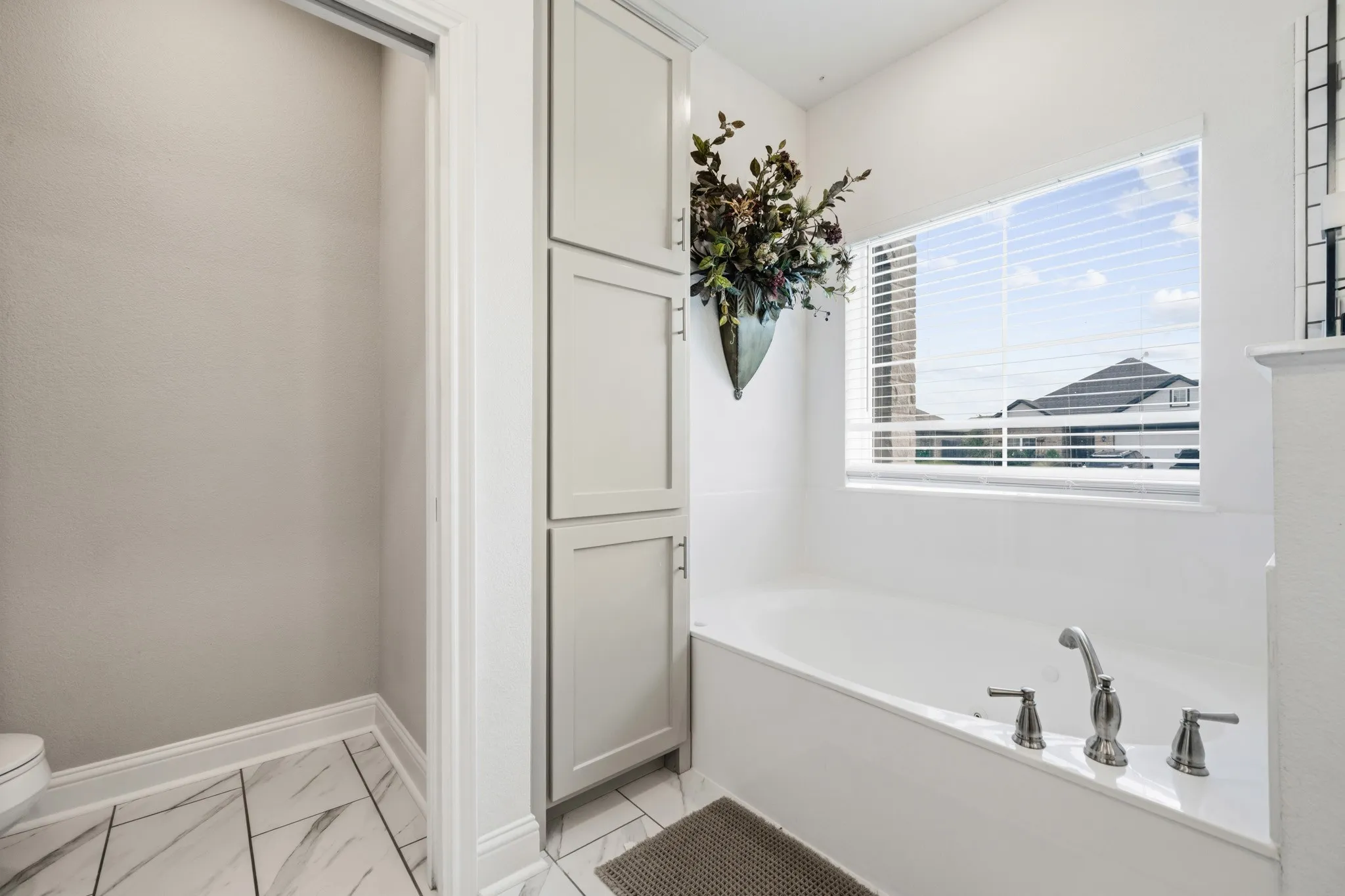 Built-in soaking tub featuring brushed nickel hardware