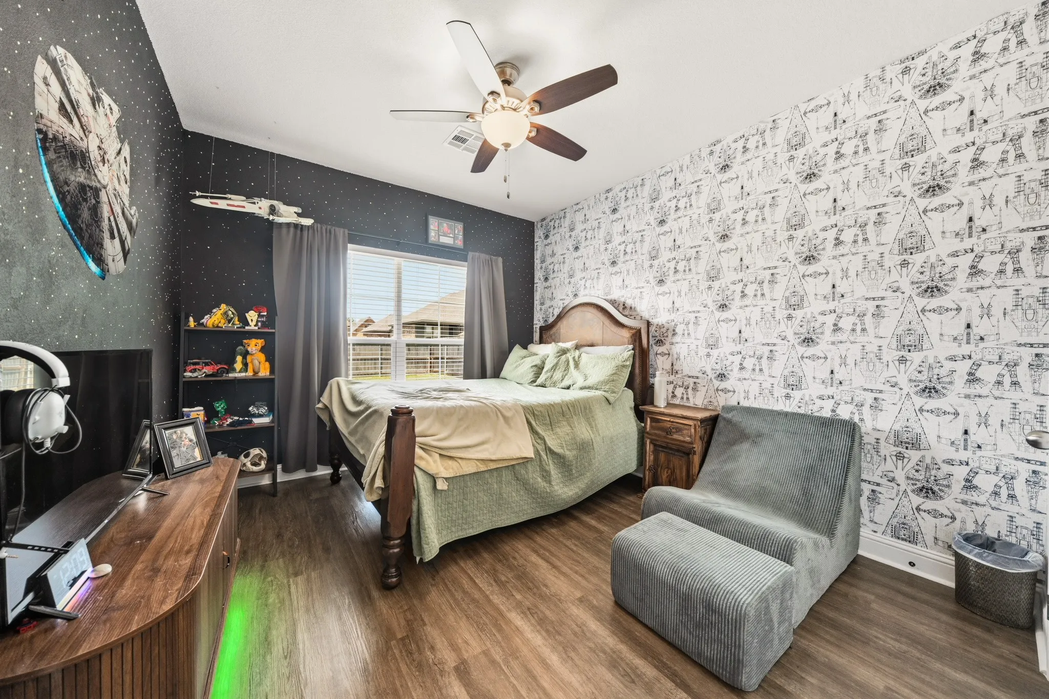Bedroom featuring wood-finish flooring, a ceiling fan, and a window with blinds