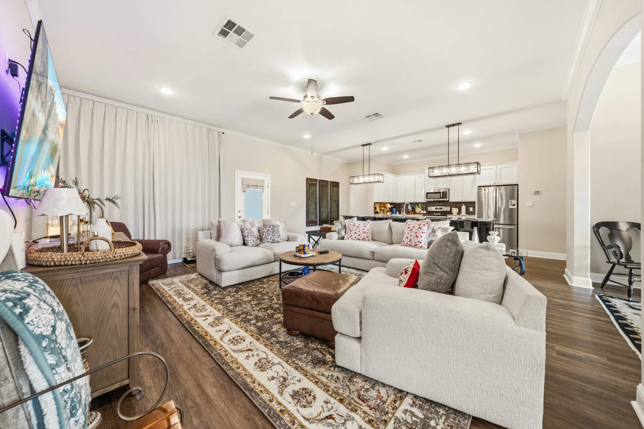 Open-concept living area featuring wood-finish flooring, recessed lighting, and a ceiling fan