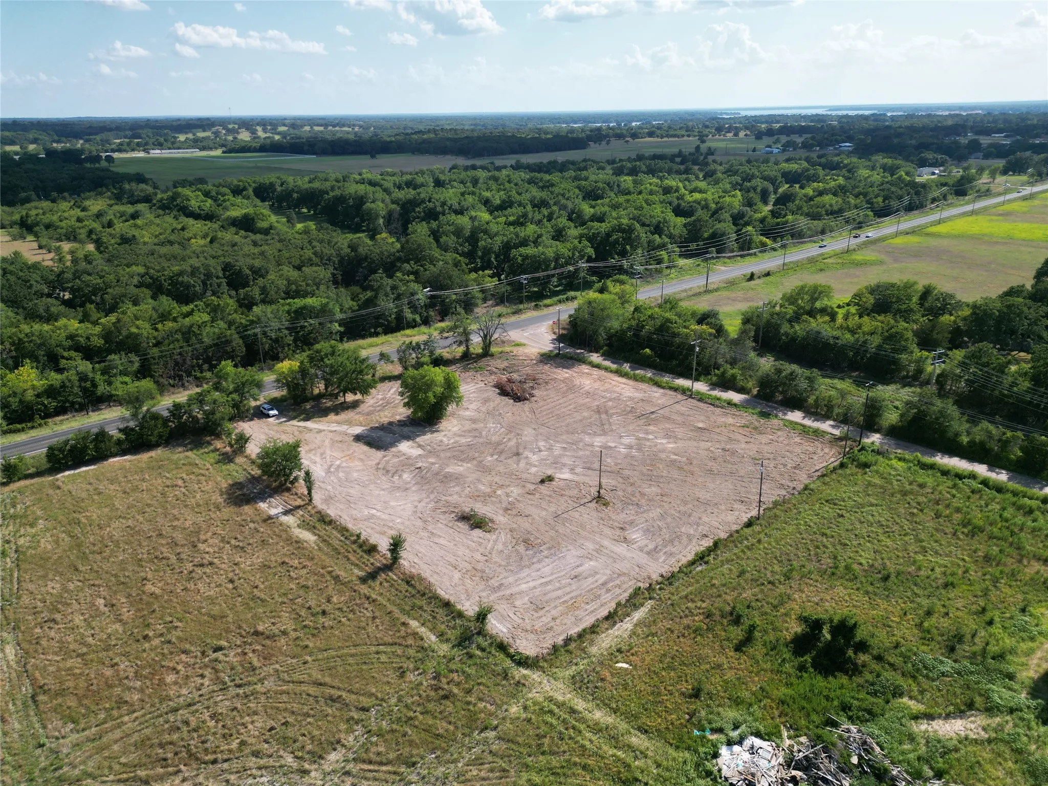 Expansive cleared lot with perimeter fencing and direct road frontage