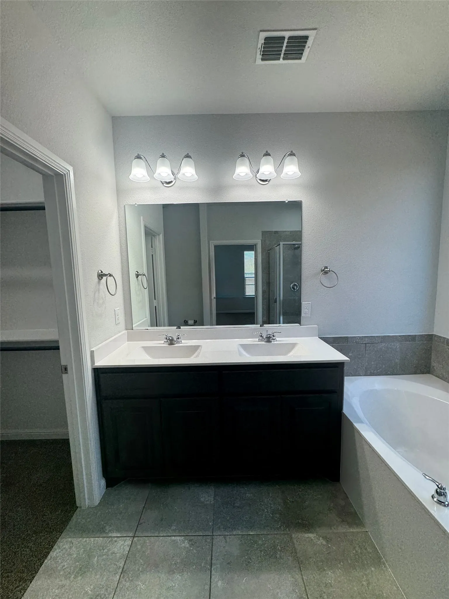 Dual vanity with white undermount sinks, chrome fixtures, and a white countertop