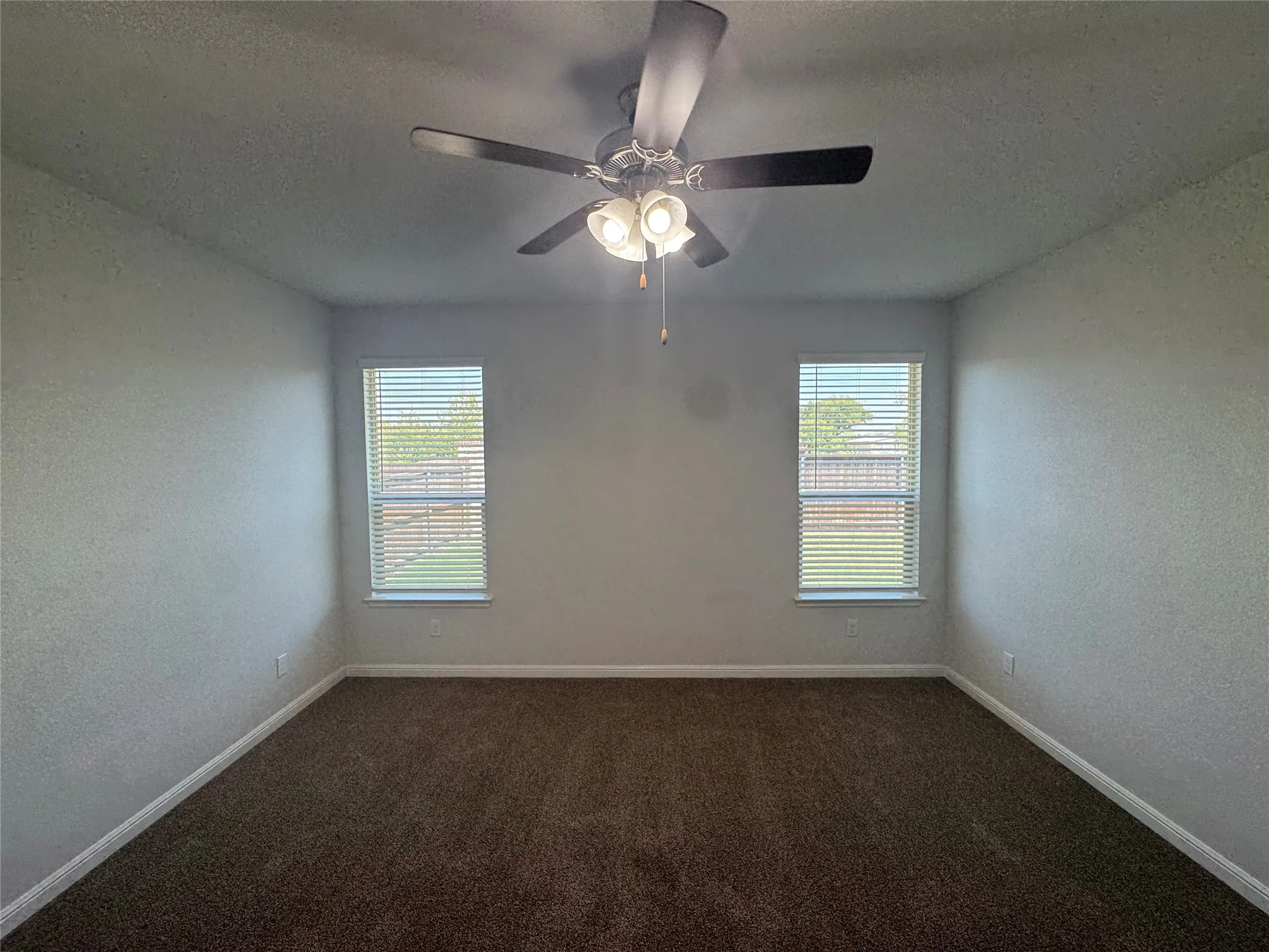 Recessed windows with horizontal blinds and ceiling fan with integrated lighting