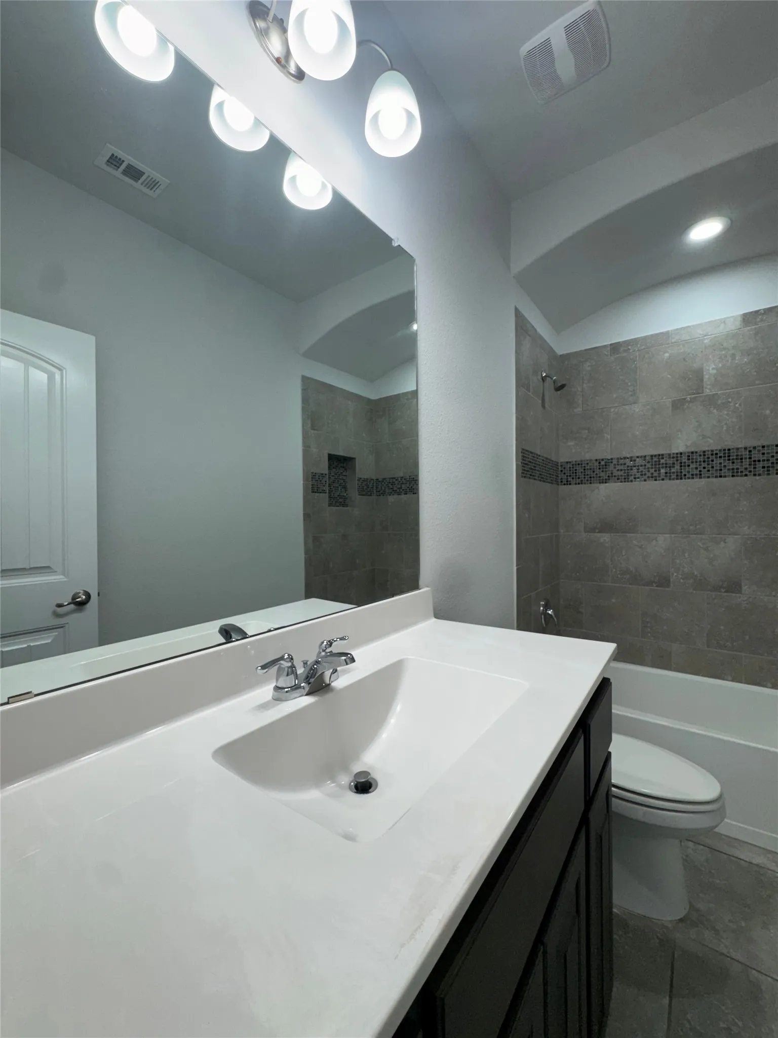 Vanity with an integrated sink, dark wood-finish cabinetry, and a chrome faucet