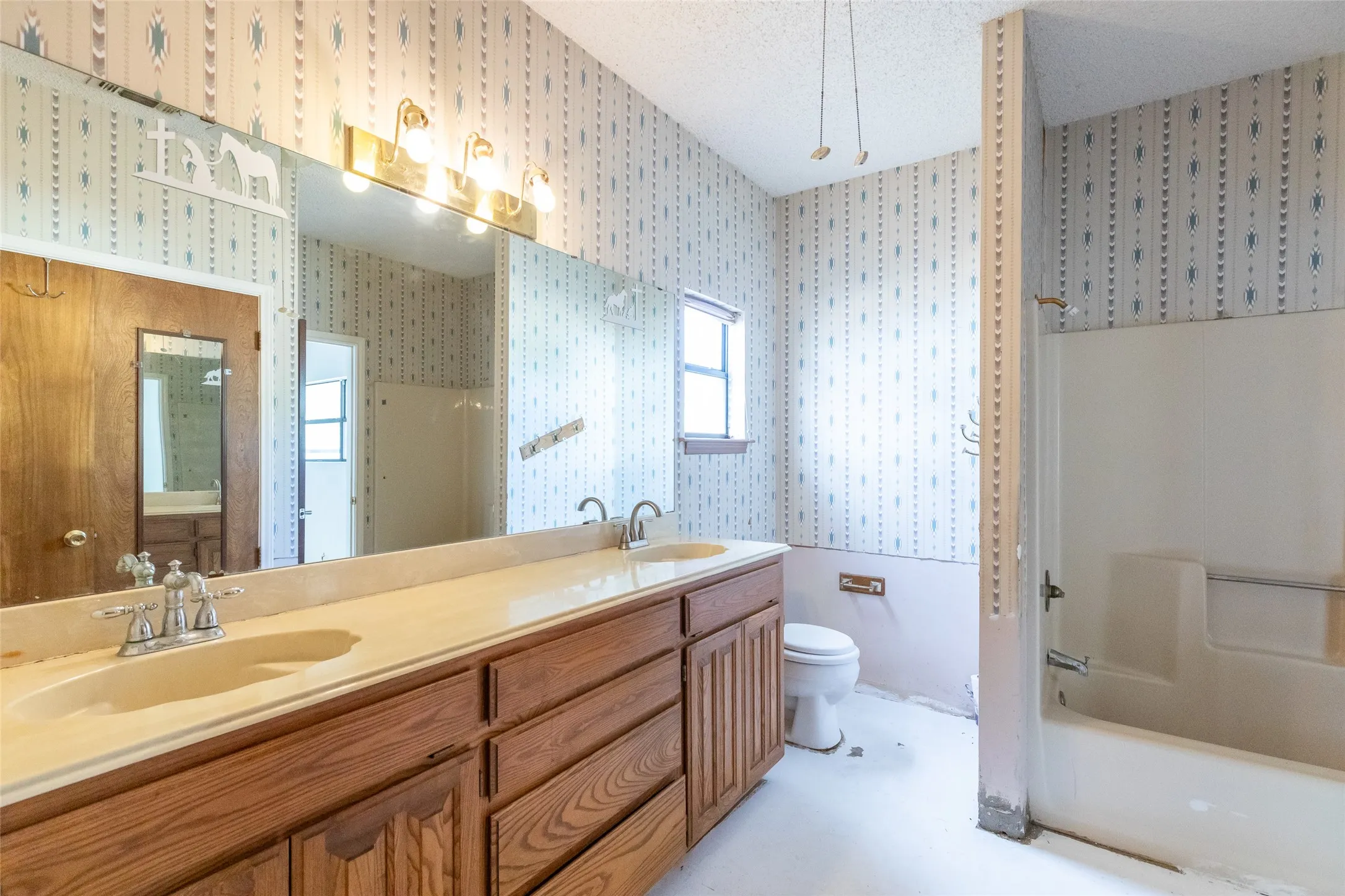 Double vanity featuring two integrated sinks, individual faucets, and wood-finish cabinetry with multiple drawers