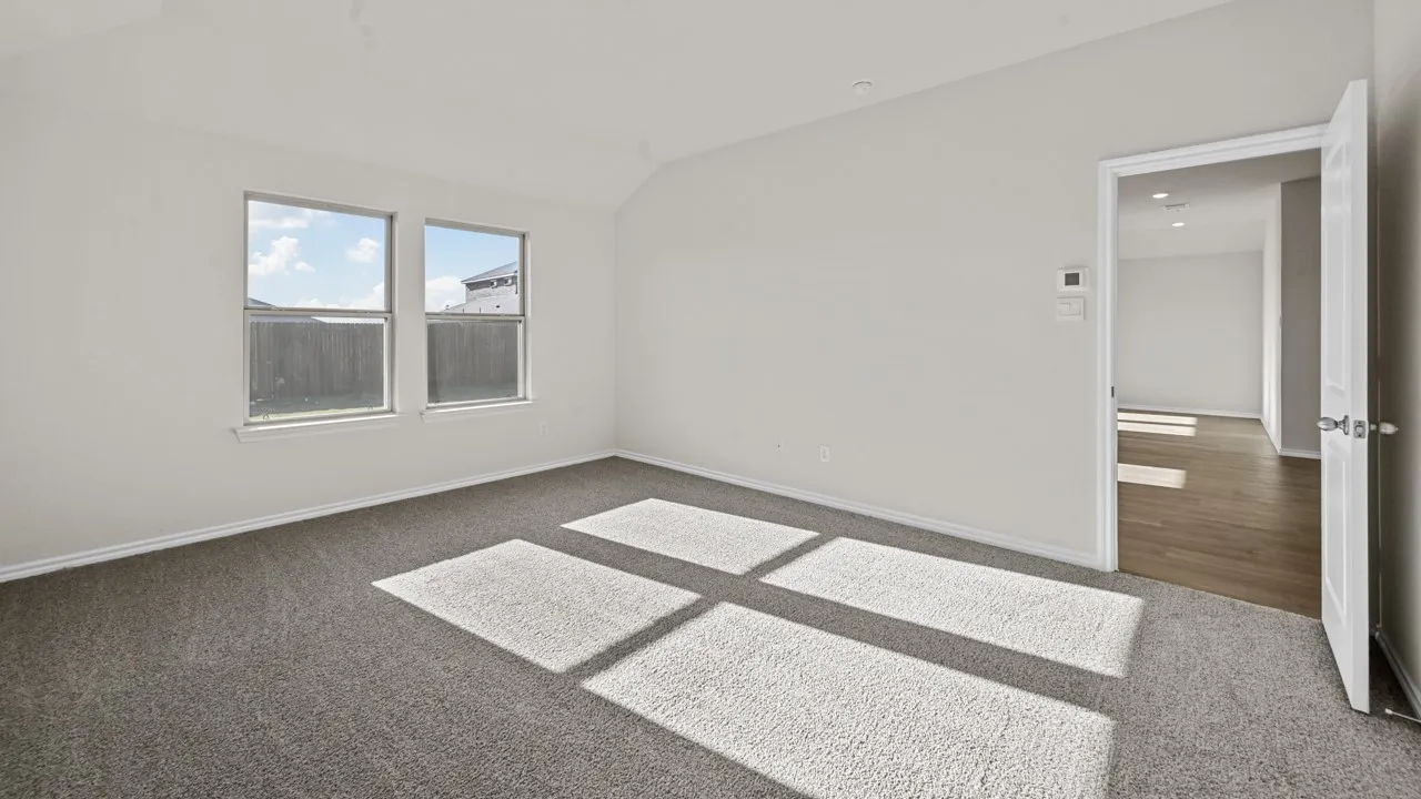 Carpeted room with two windows and a white paneled door