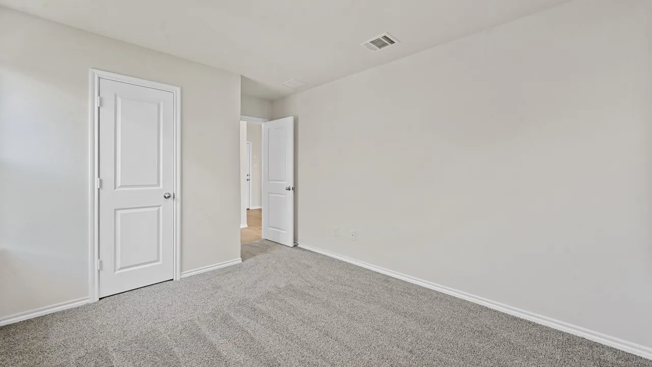 Neutral tone walls, grey carpet flooring, white trim, and white two-panel doors