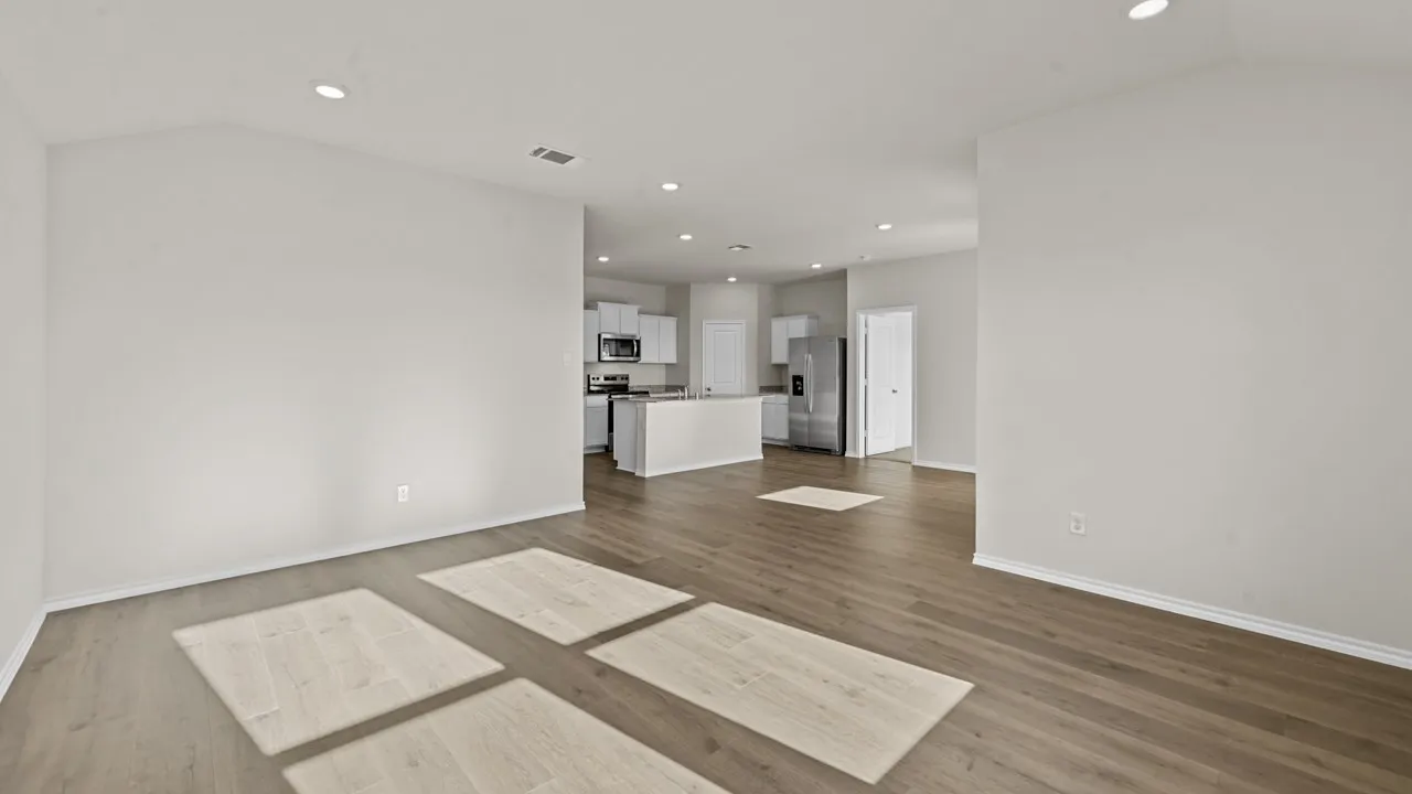 Spacious room featuring vaulted ceilings, recessed lighting, and wood-finish flooring