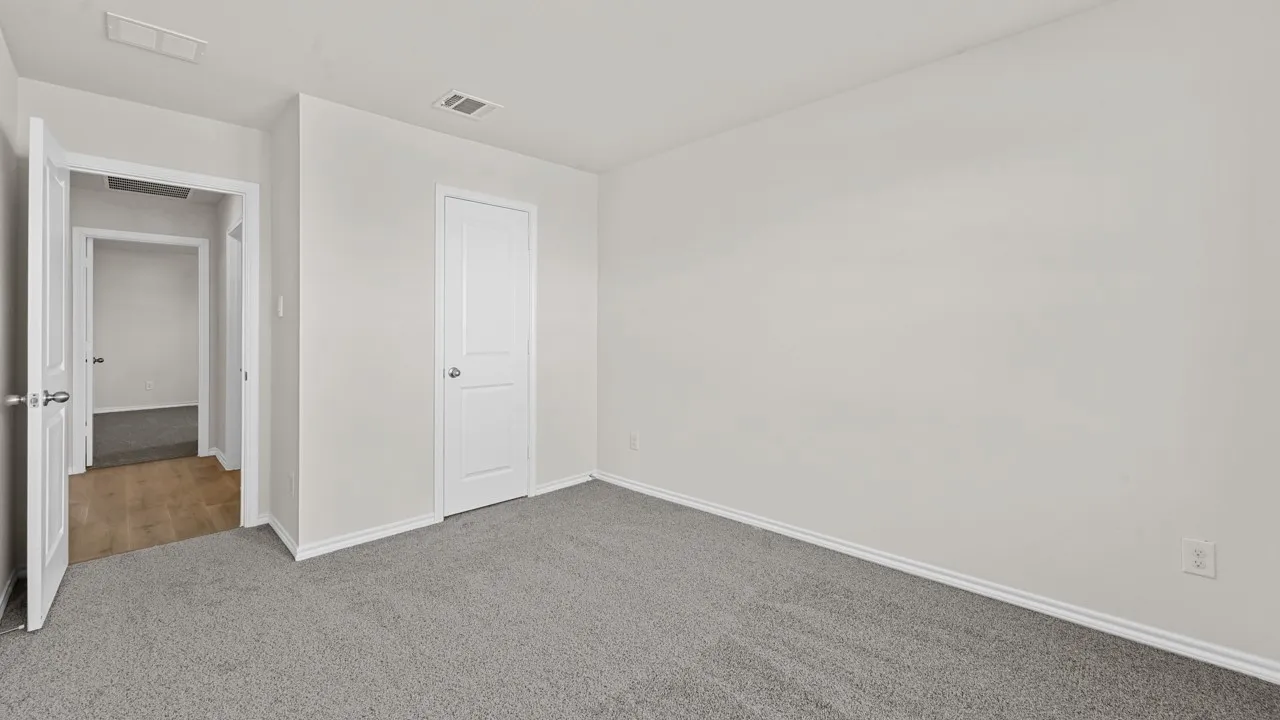 Spacious room featuring light gray carpeting and white trim